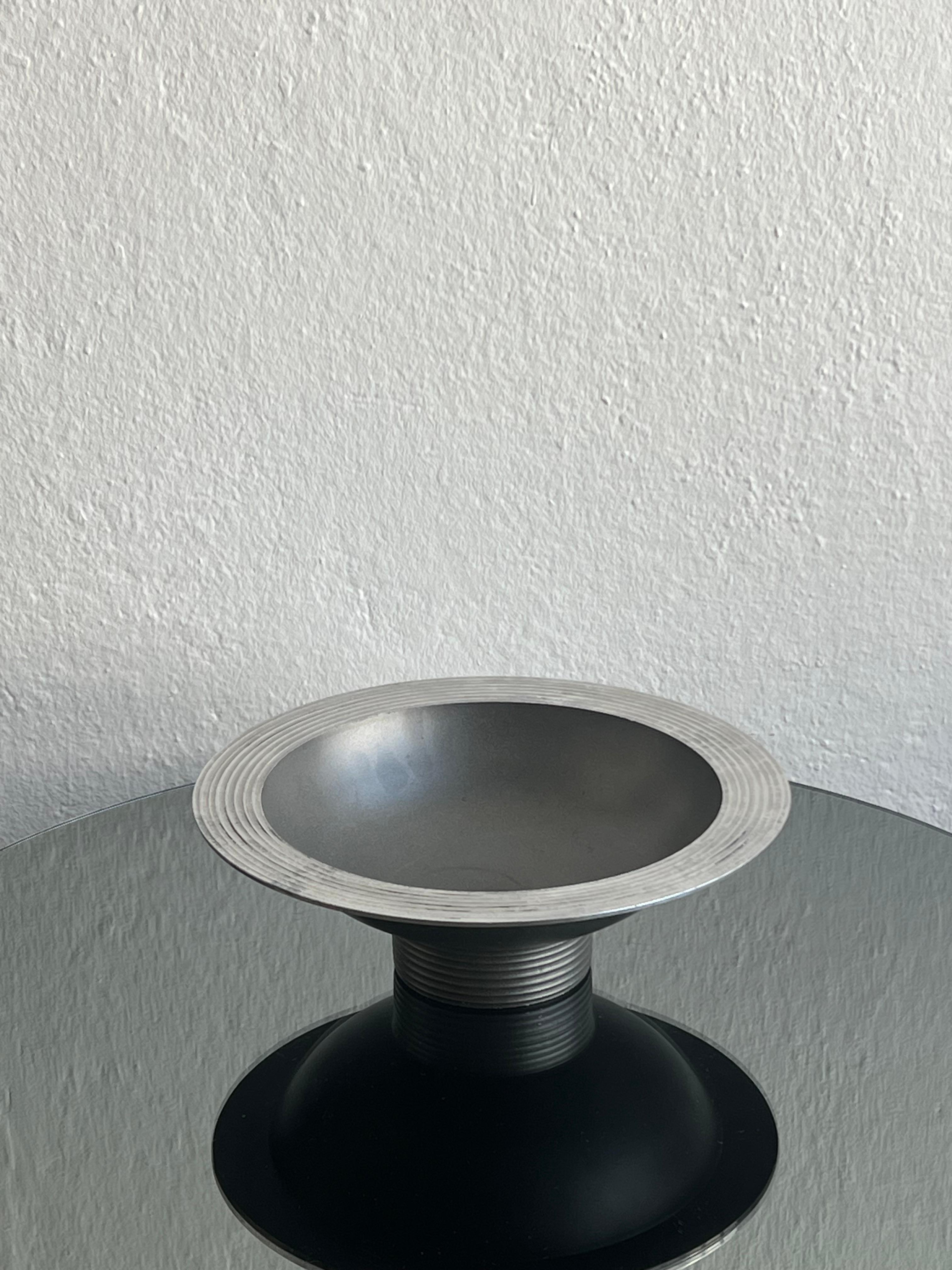 Centre de table bol à fruits art déco en métal, centre de table, accessoire de stylisme.

 Demi-coupelle ronde avec une large bordure plate avec des lignes parallèles et concentriques gravées dans le métal créant un motif intéressant et minimal