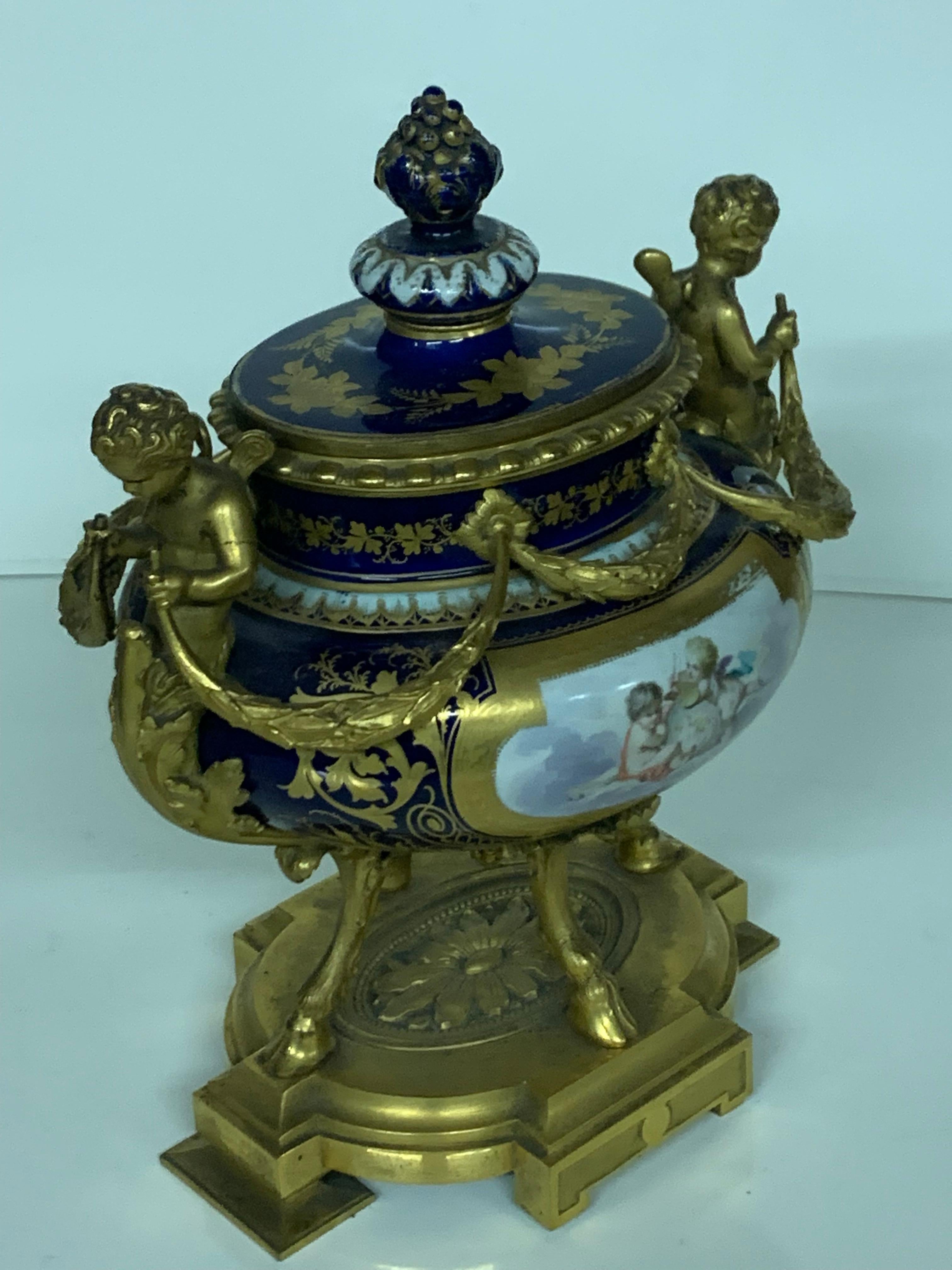 Wunderschönes Parfüm aus Porzellan im Sèvres-Stil, Ormolu-Bronze mit Cherub auf jeder Seite, der Deckel ist mit einem Pinienkern aus Porzellan verziert.
