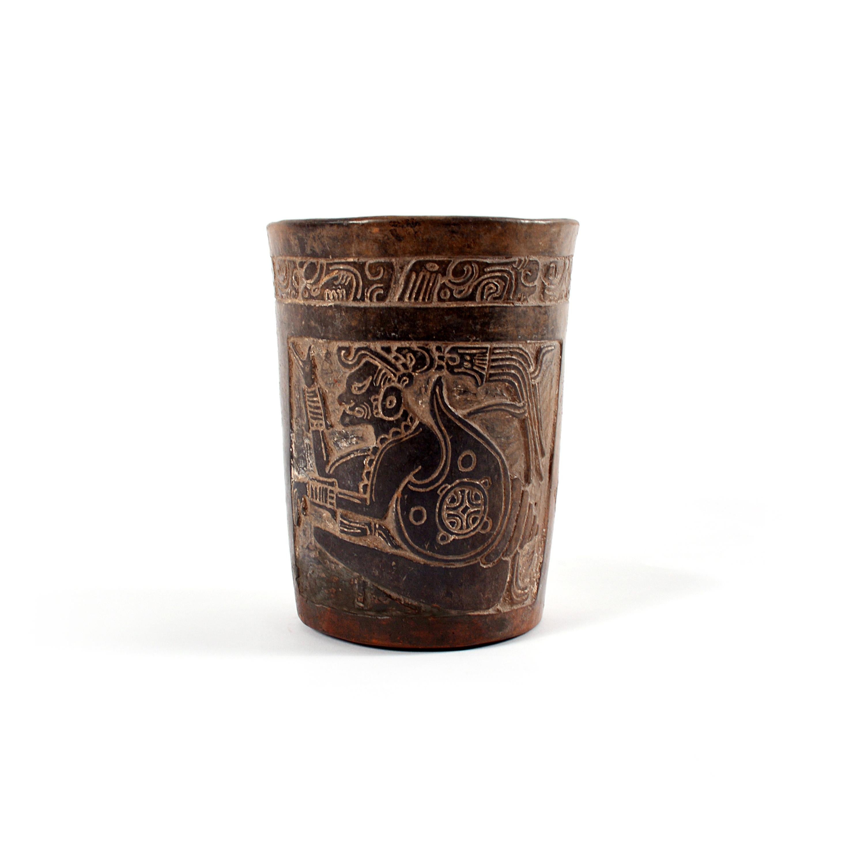 High Mayan brown ware vessel carved on two sides with the seated and gesturing figure of a dignitary within frame. A band of glyphs encircles the rim. From the Late Classic Period (ca. 550 – 950 AD).

With TL-analysis from Laboratory Ralf Kotala,