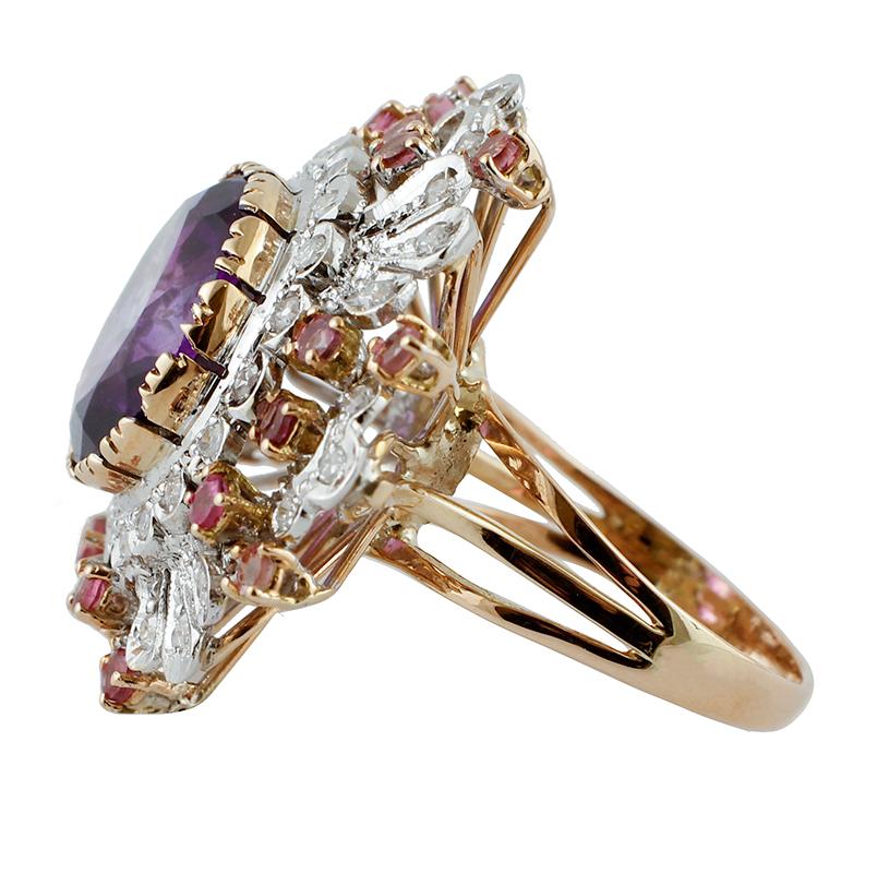 Retro ring in 14k rose and white gold structure, mounted with a central intense amethyst, surrounded by flowery decoration in white gold studded by beautiful diamonds and tourmalines.
The origin of this beautiful ring goes back to the 1980s, it was