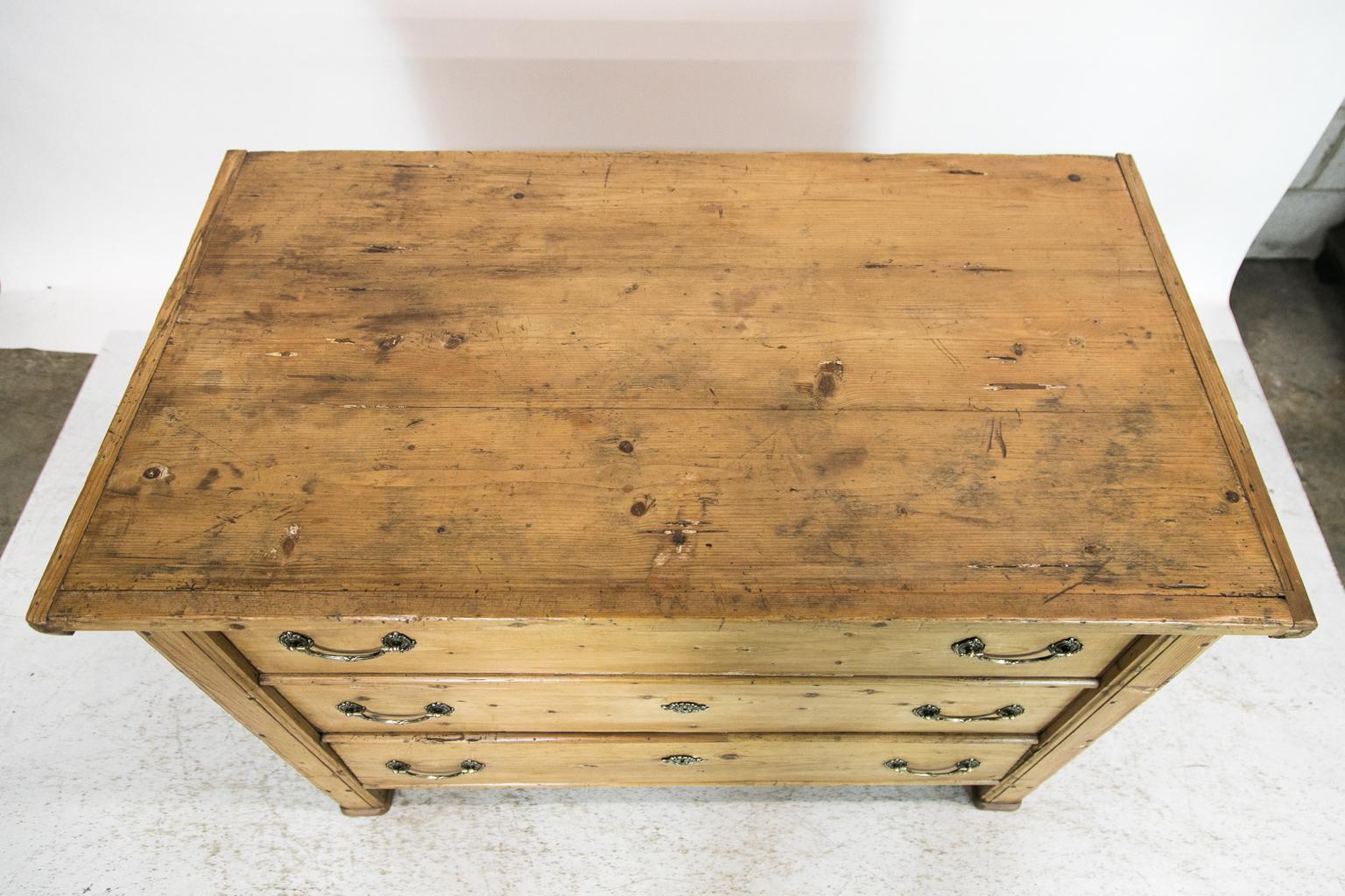 This Central European blanket chest has a front that simulates a three-drawer chest. The top two drawers are dummies while the lower is a functioning drawer. The front and back have exposed dovetail construction. The steel handles on the sides are