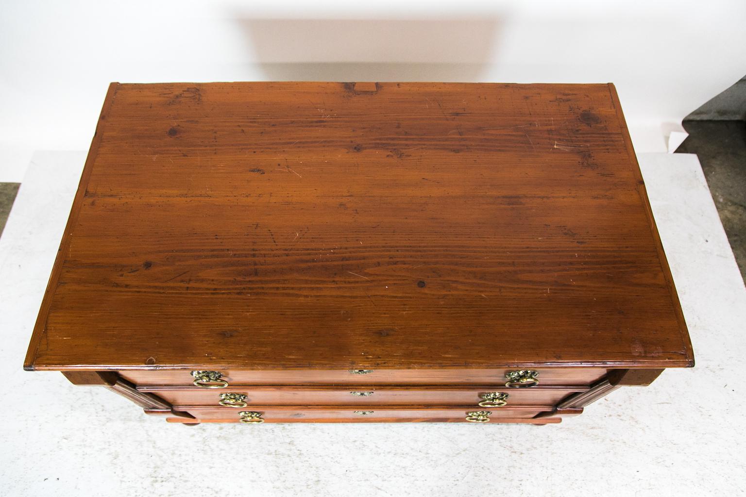 The front of this Central European pine chest is designed with two top drawers being dummy disguising the lift top blanket chest interior. The lower drawer is functioning. The drawer dividers have molded shapes. The drawers are framed with carved