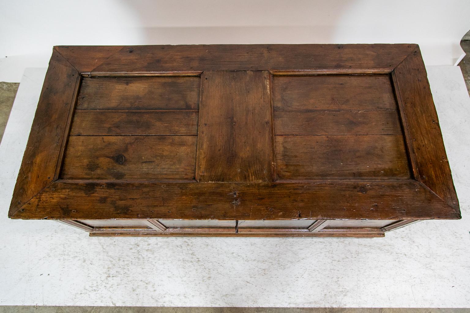 The front of this painted blanket chest has three recessed panels framed with shaped moldings. It retains its original steel lock and working key. The top has two recessed panels framed by shaped molding. There are shrinkage cracks in these panels