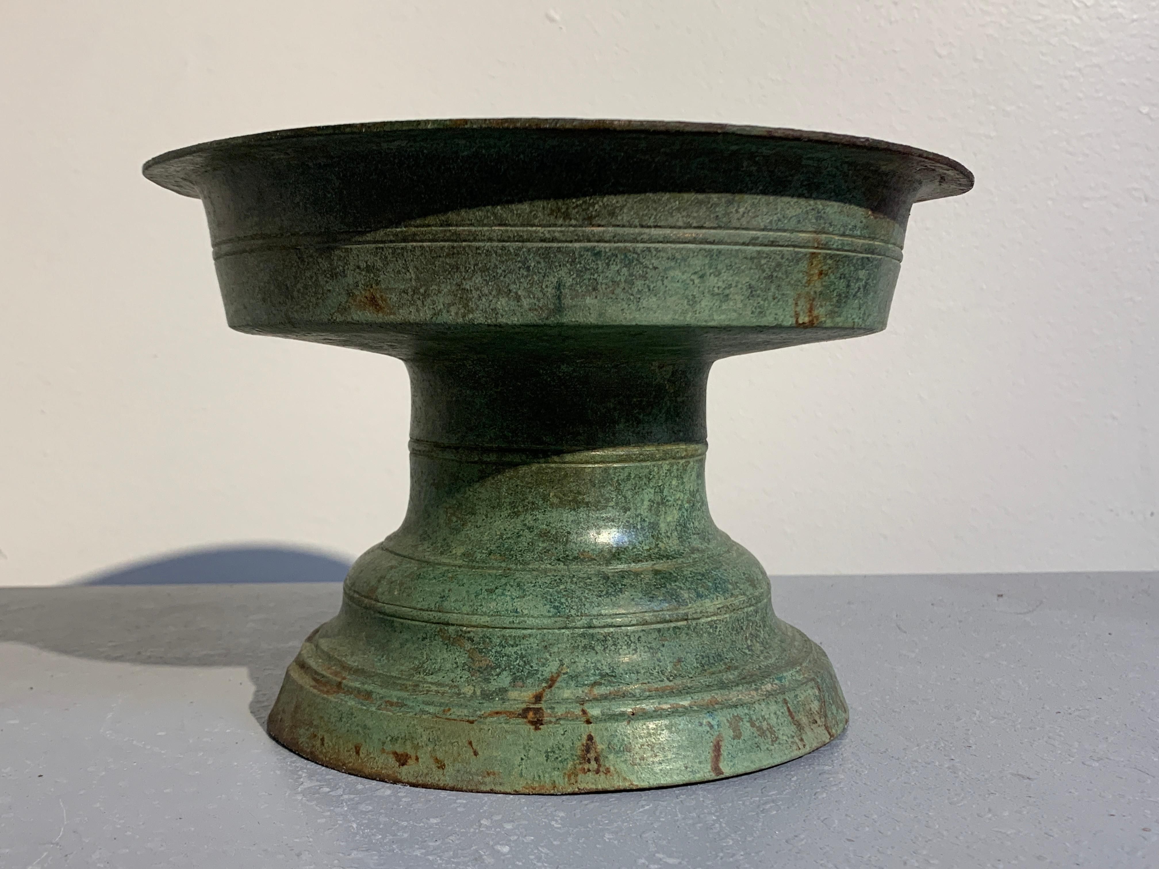 A gorgeously patinated bronze pedestal offering tray, talam, Central Javanese Period, Java, 8th-10th century.

The offering tray of beautiful form and proportions, with a splayed and stepped foot rising to a waisted pedestal supporting the
