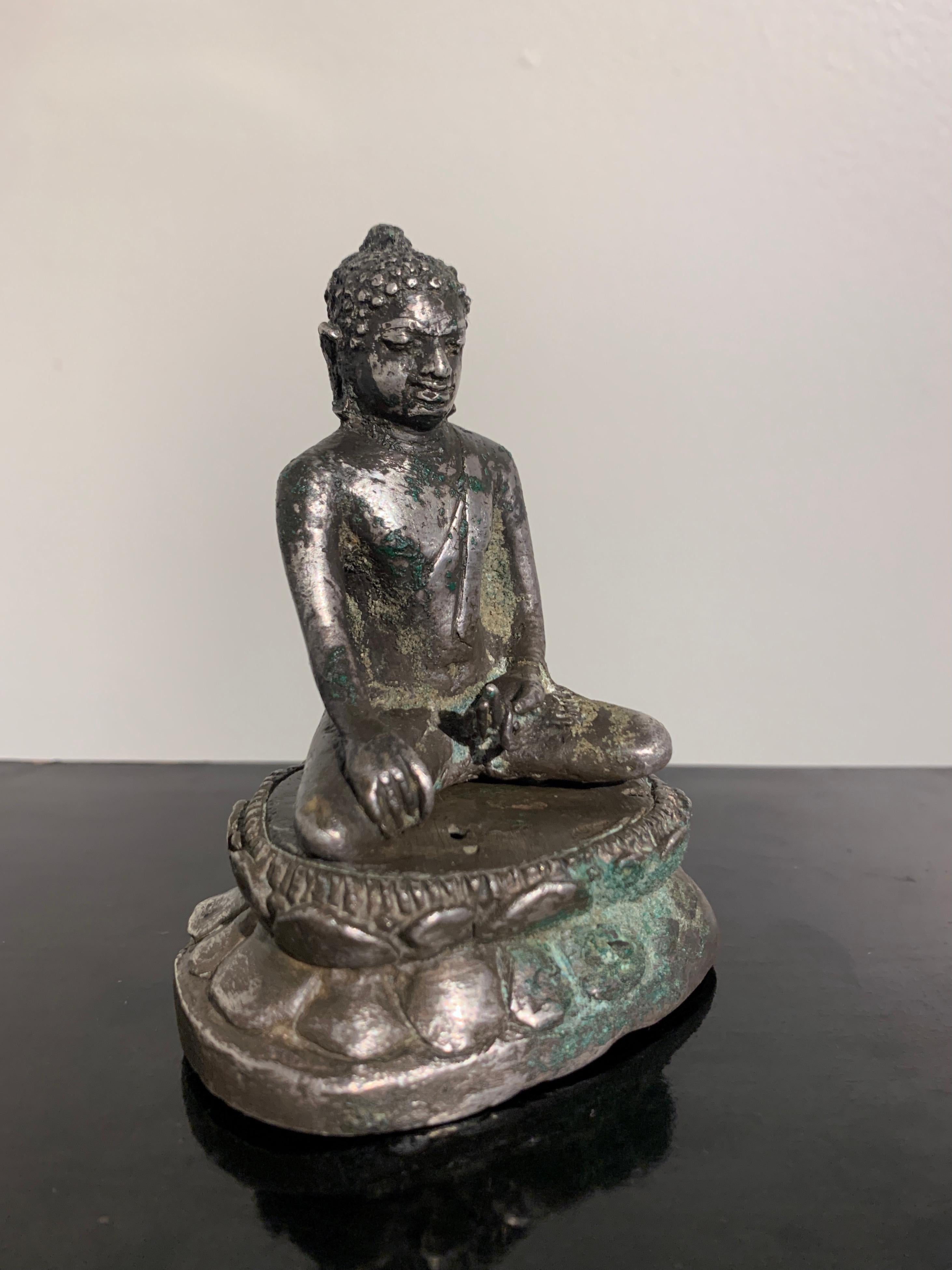 Très rare figure javanaise en argent coulé représentant un Bouddha transcendant, probablement le Dhayani Buddha Akshobhya, début de la période classique javanaise, 9e - 12e siècle, Java, Indonésie. 

Coulé en argent, le Bouddha ésotérique,