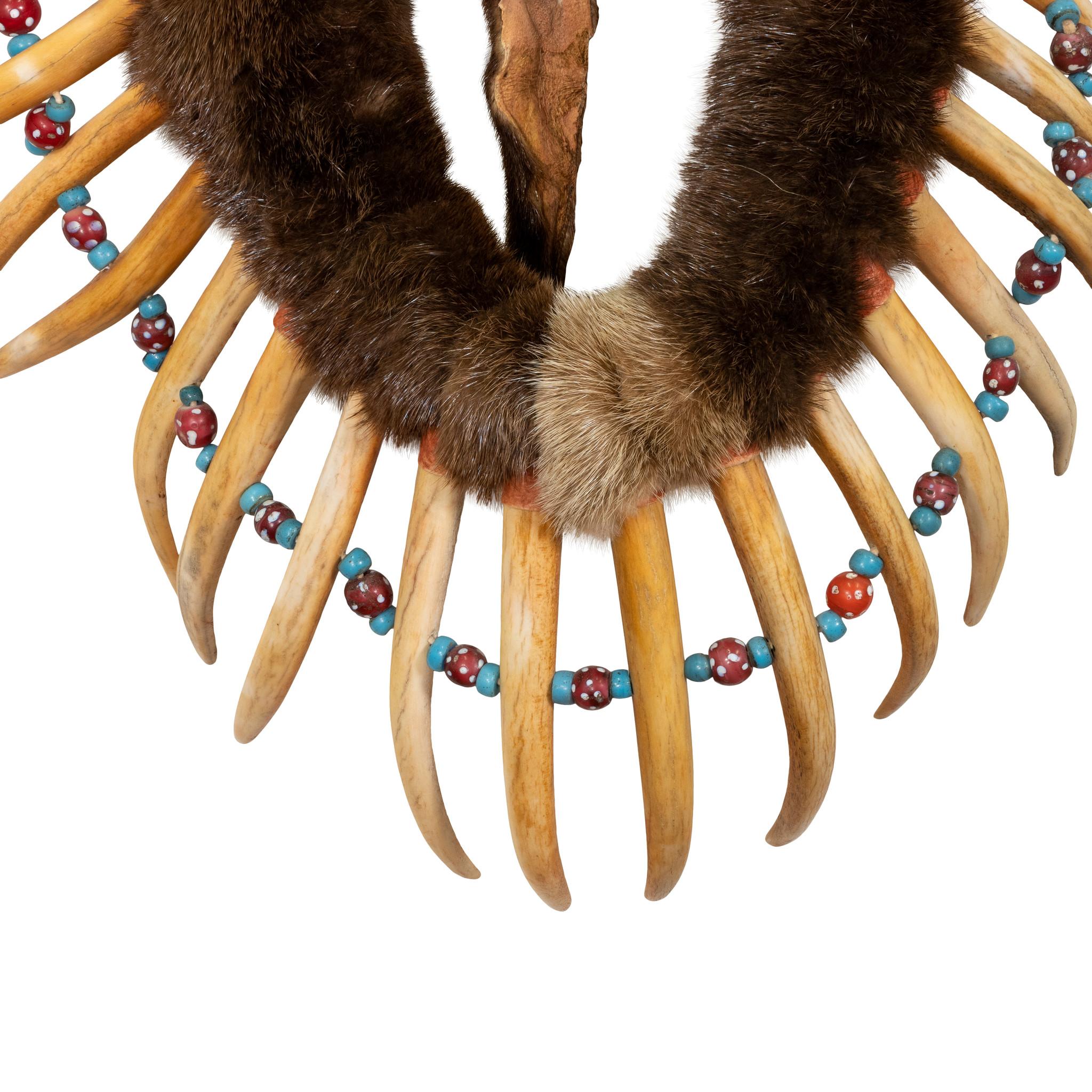 Central plains warrior's otter skin breastplate/necklace with hand carved and painted deer antlers simulating grizzly claws. Venetian beads strung in between. Ex. Private museum

Period: Last half 20th Century
Origin: Central Plains
Size: Antlers 7