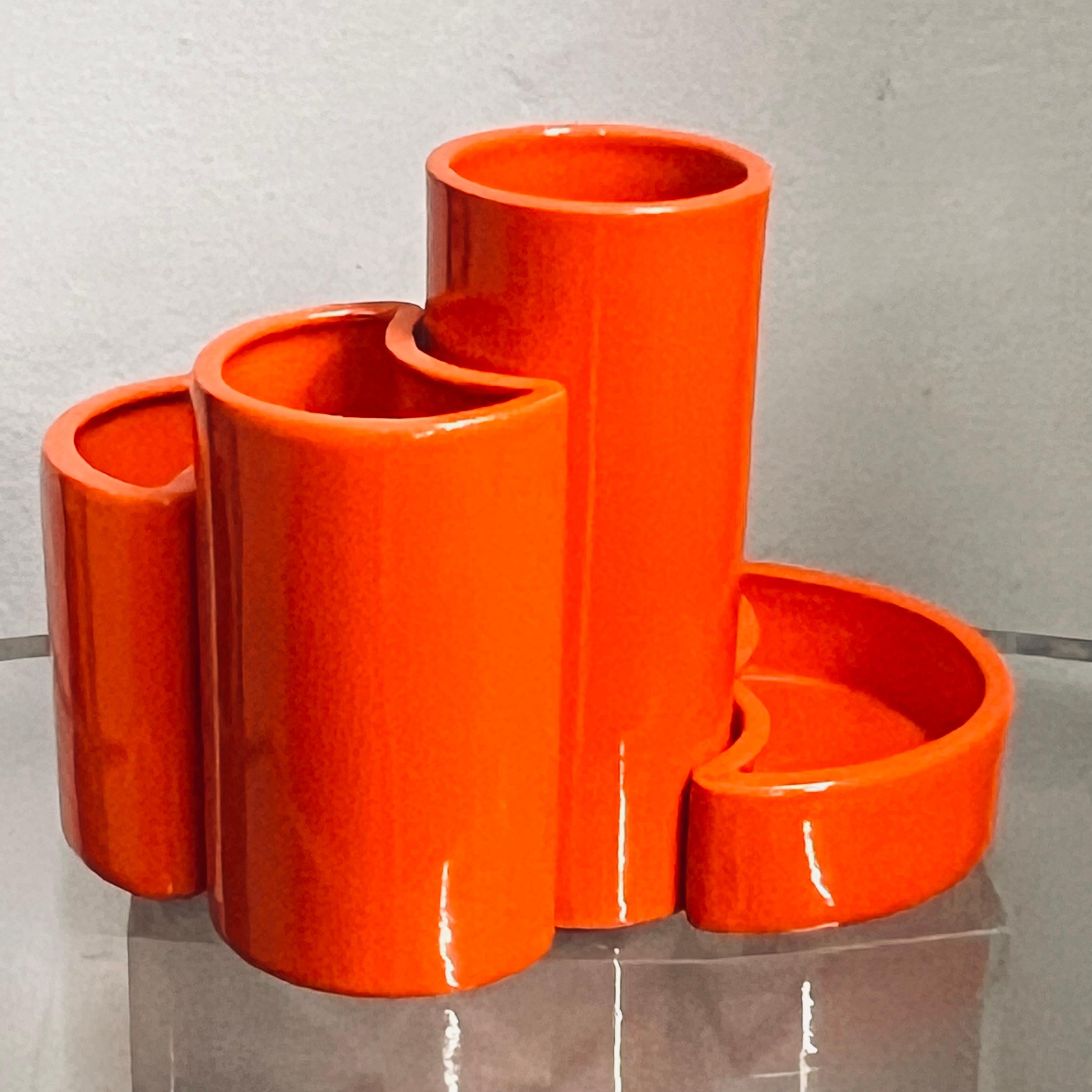 Curious group of five Italian ceramics, bright and cheerful orange and of different shapes and sizes that make up a single spiral centerpiece.
On the bottom, all of them are covered with light cloth, except for two that appear to bear a poorly