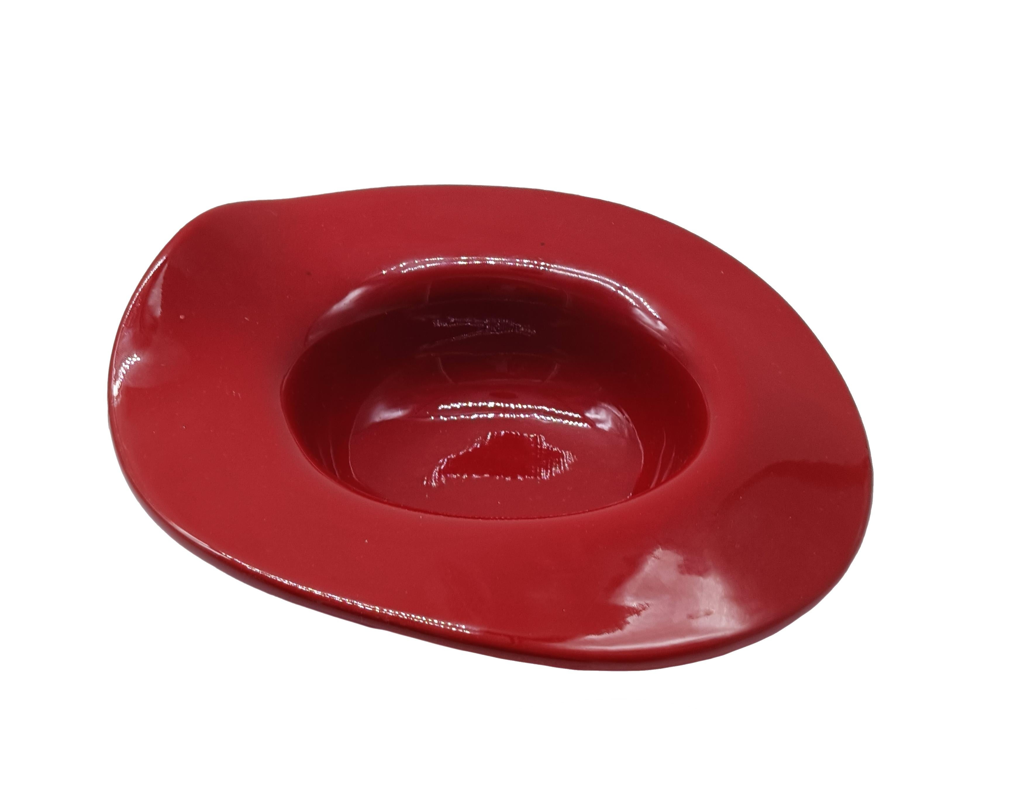 Delizioso centrotavola in ceramica di colore rosso rubino smaltato, Italia 1970. La sua forma particolare, con bordi rialzati e ondulati, lo rende un pezzo distintivo e potenzialmente artistico. 