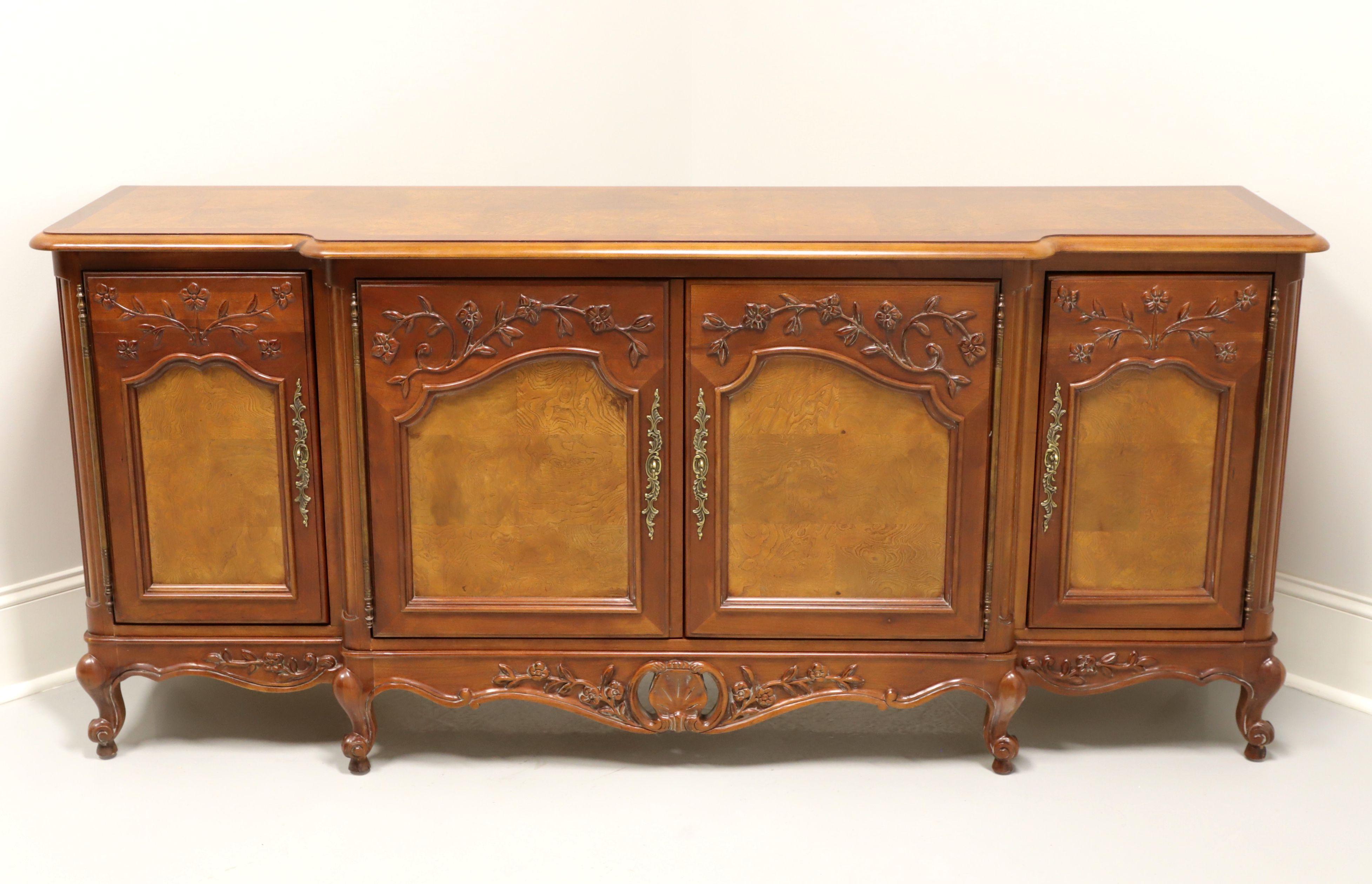 An oversized sideboard / credenza in the French Country Louis XV style by Century Furniture. Elm & inlaid burl elm, brass hardware, breakfront shape, banded top, carved door fronts, carved apron and scroll feet. Features two center solid doors