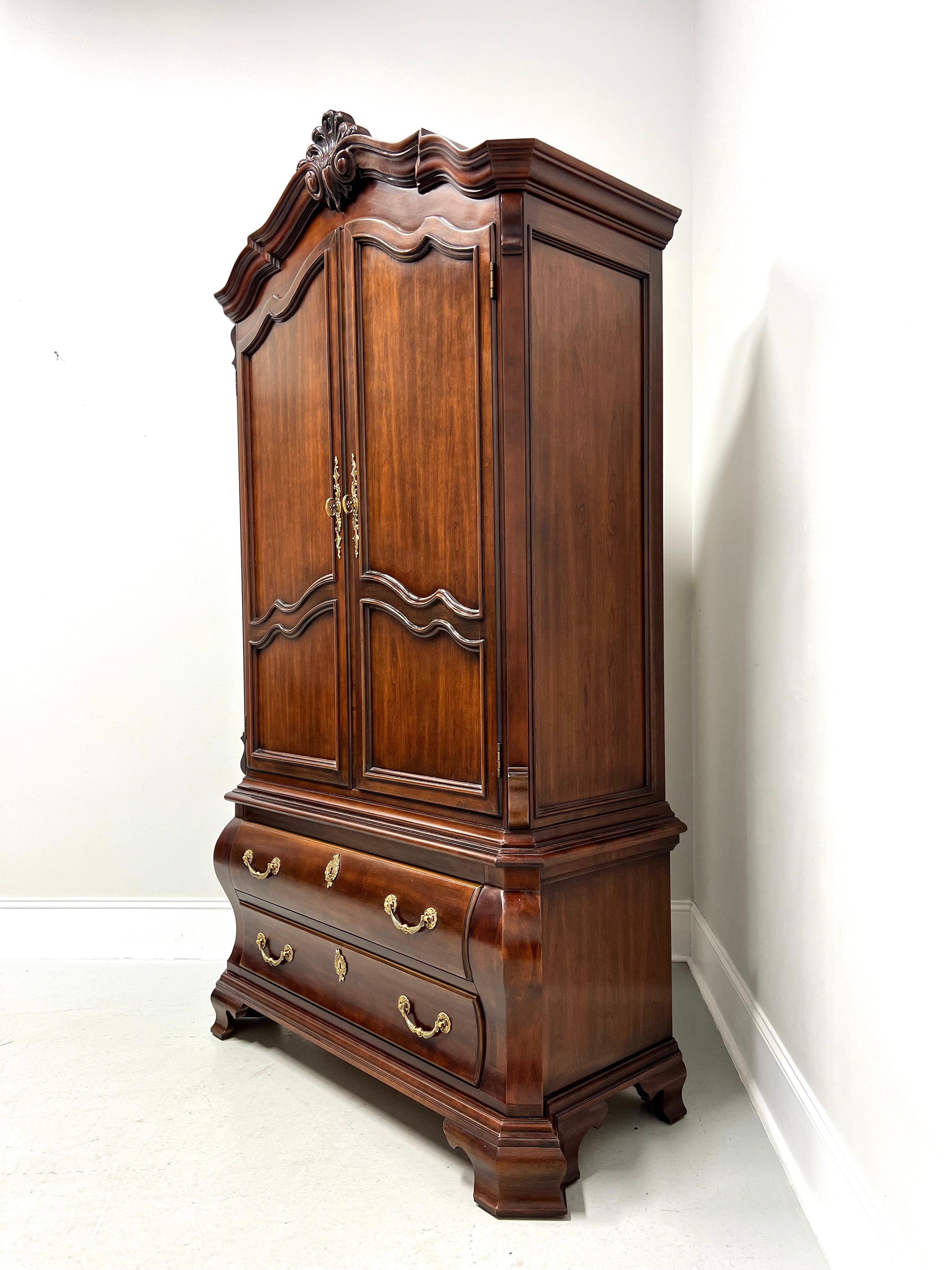 An Italian Provincial style armoire / linen press by Century Furniture, from their Cardella Collection. Cherry wood with decorative brass hardware, crown molding with carved details, arched doors, bombe shape & clipped corners to lower chest, and