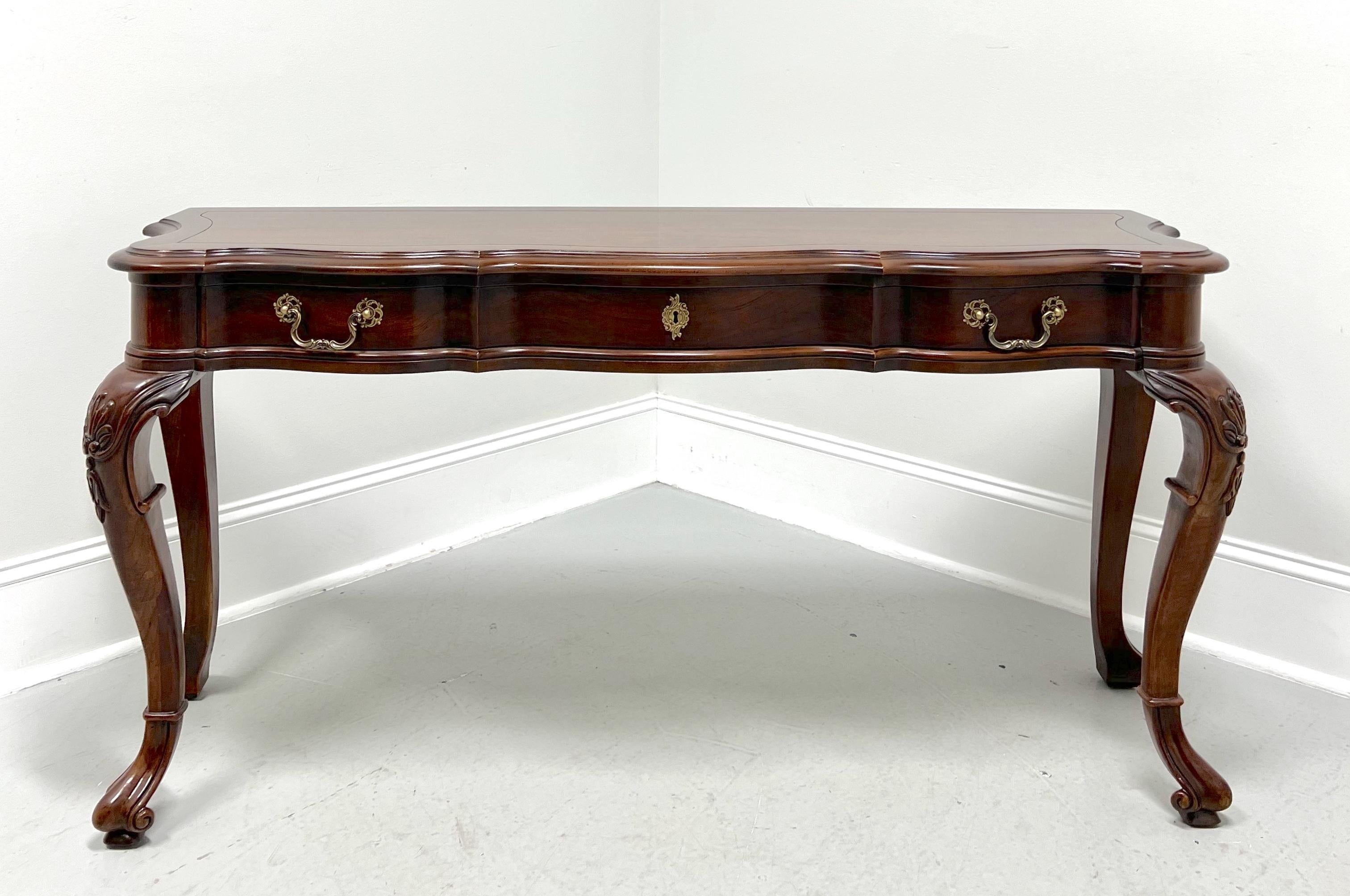 An Italian Provincial style sofa table by Century Furniture, from their Cardella Collection. Cherry wood with decorative brass hardware, banded top with an ogee edge & rounded corners, serpentine shape, carved knees, cabriole legs, and hoof-like