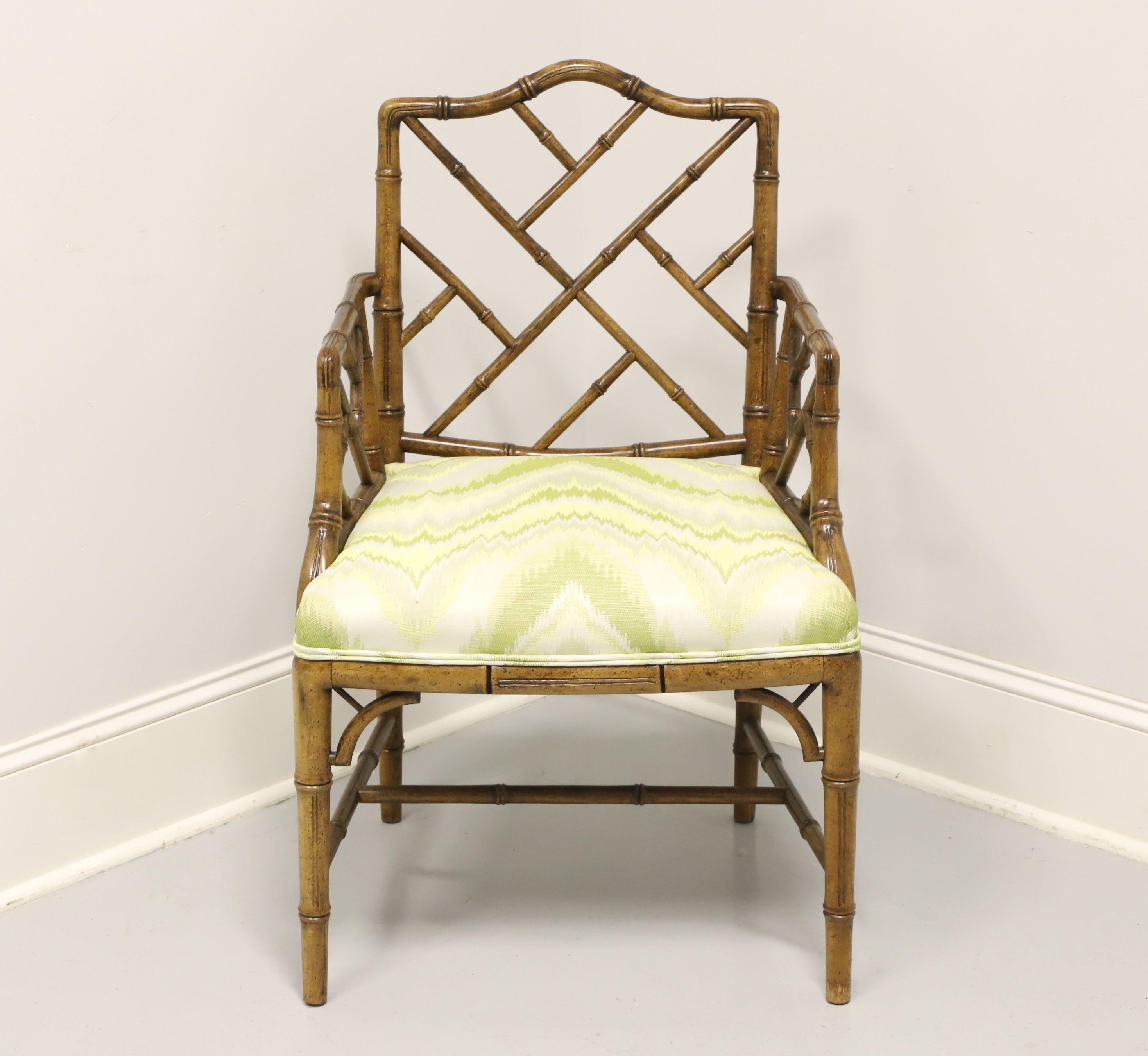 A Chinese Chippendale style armchair by Century Chair Company. Faux bamboo frame with decorative lattice back, curved arms with lattice, green & white color flame pattern fabric upholstered seat, lattice accents to front corners under apron, tapered