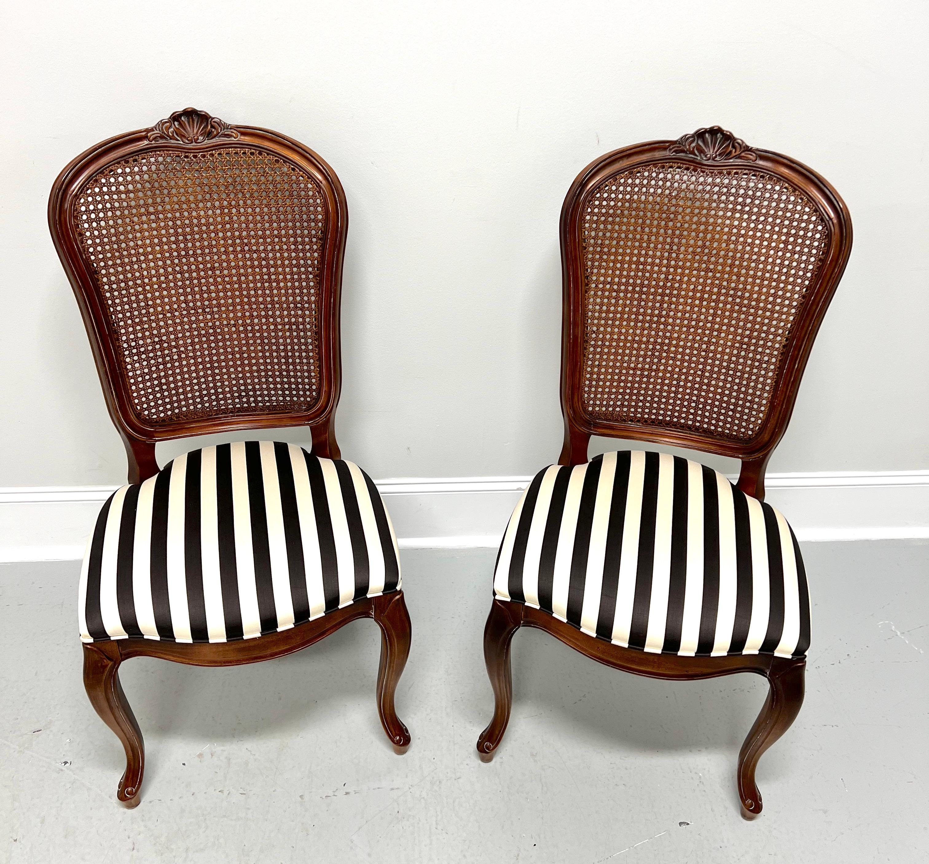 A pair of French Provincial style dining side chairs by Century Furniture, from their Chardeau Collection designed by Raymond K Sobota. Solid cherry wood, carved detail to crest rail, caning to backrest, black & white stripe pattern fabric