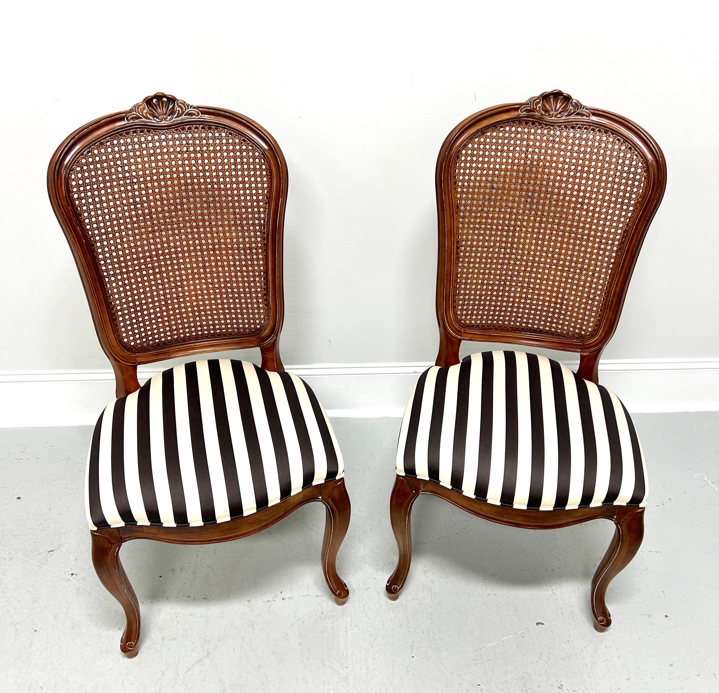A pair of French Provincial style dining side chairs by Century Furniture, from their Chardeau Collection designed by Raymond K Sobota. Solid cherry wood, carved detail to crest rail, caning to backrest, black & white stripe pattern fabric