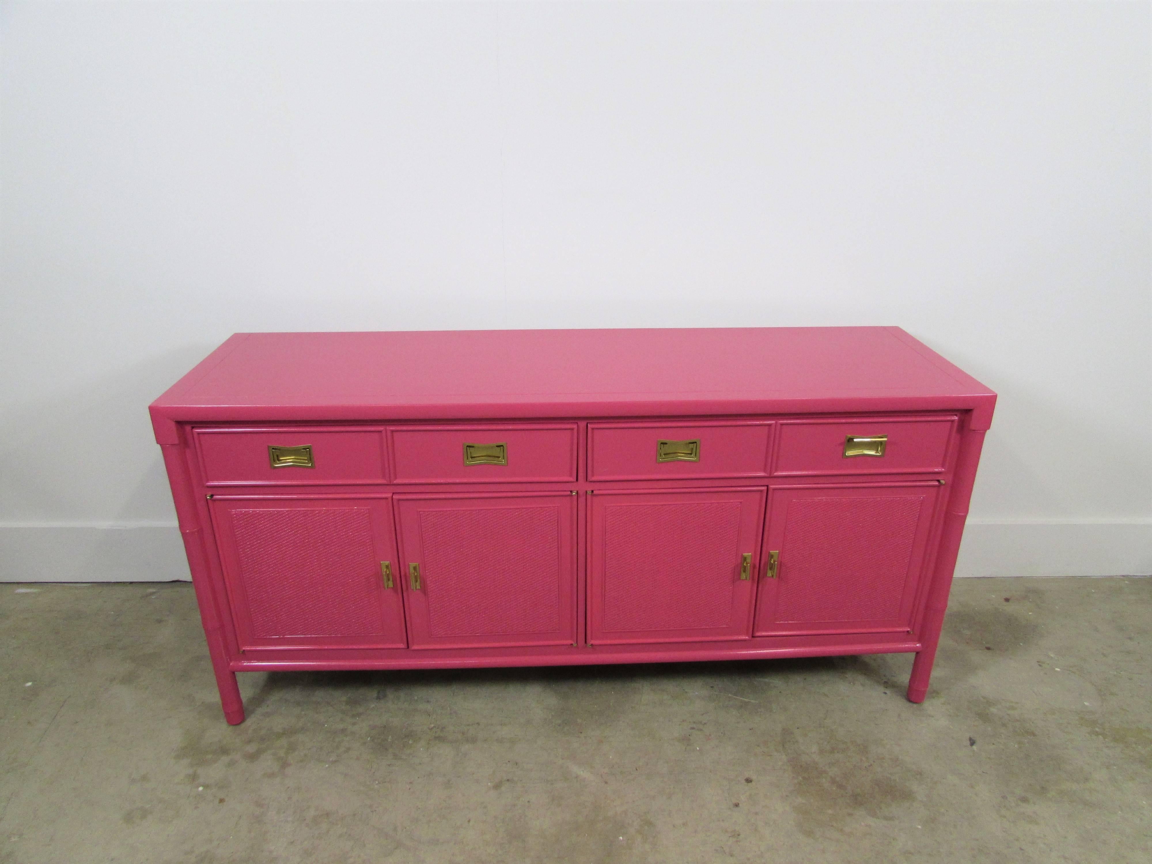 Century faux bamboo and cane Credenza Lacquered In-house in Benjamin Moore Peony Pink gloss finish with two upper drawers under four swinging doors and brass recessed hardware under our custom gold. Interior drawers and cabinets are lined in