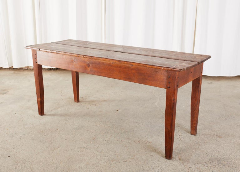 Rustic and simple country French pine farmhouse table constructed from pine. Petite sized that could serve as a dining table measuring 22 inches from the floor to the apron or as a console table. Crafted with wood peg joinery with a plank top.