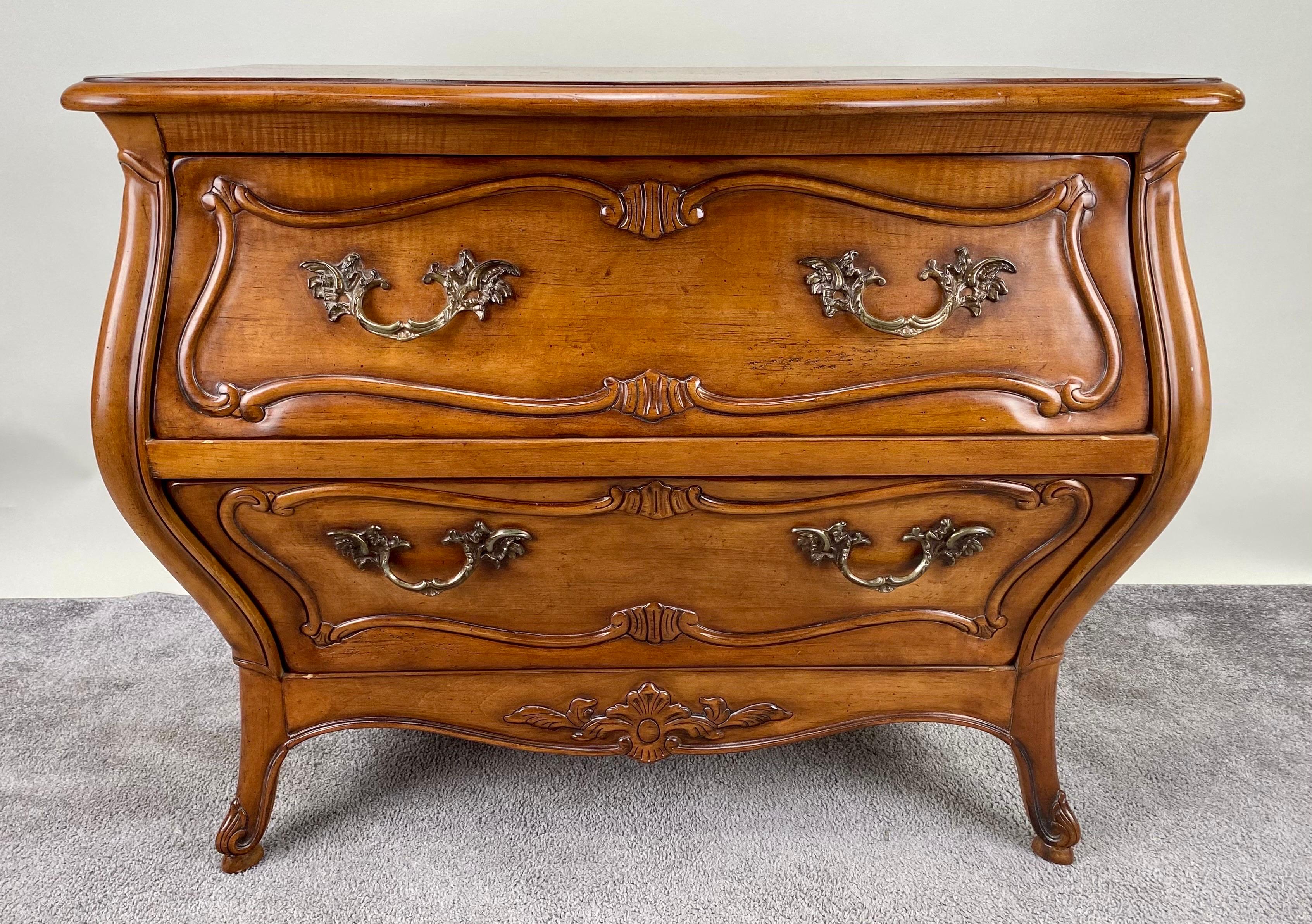  A captivating pair of Louis XV-style French Provincial Bombe nightstands or chests meticulously crafted by Century from the 