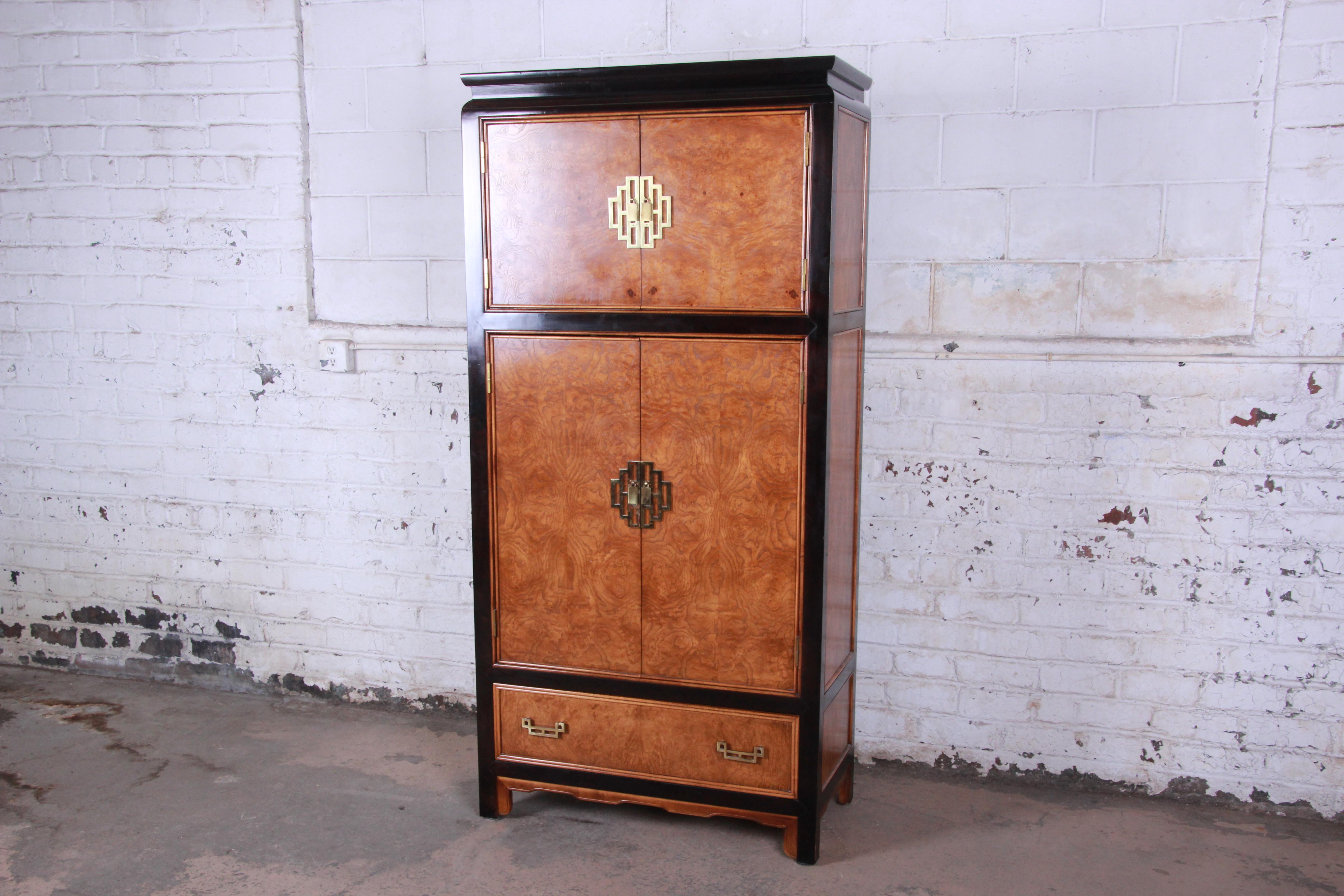 Offering a very nice Century Furniture black lacquered and burl wood chinoiserie armoire. The dresser has beautiful burl wood encased in a black lacquered finish. The top of the armoire has two cabinet doors that open to a shelf for storage. The