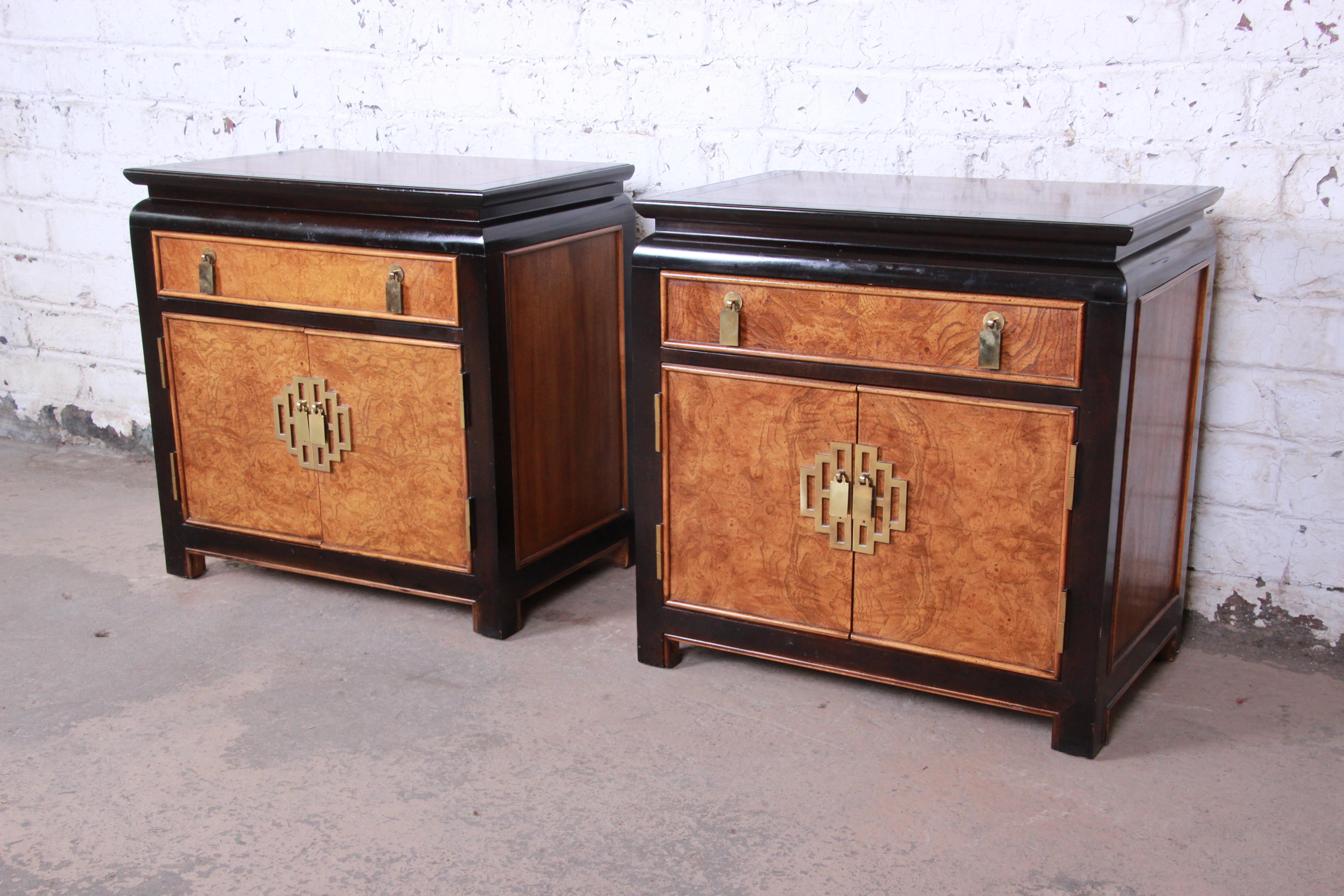 An excellent pair of Hollywood Regency chinoiserie nightstands or end tables from the Chin Hua Collection by Century Furniture. The nightstands feature gorgeous burl wood grain with black lacquered trim and original Asian-inspired brass hardware.