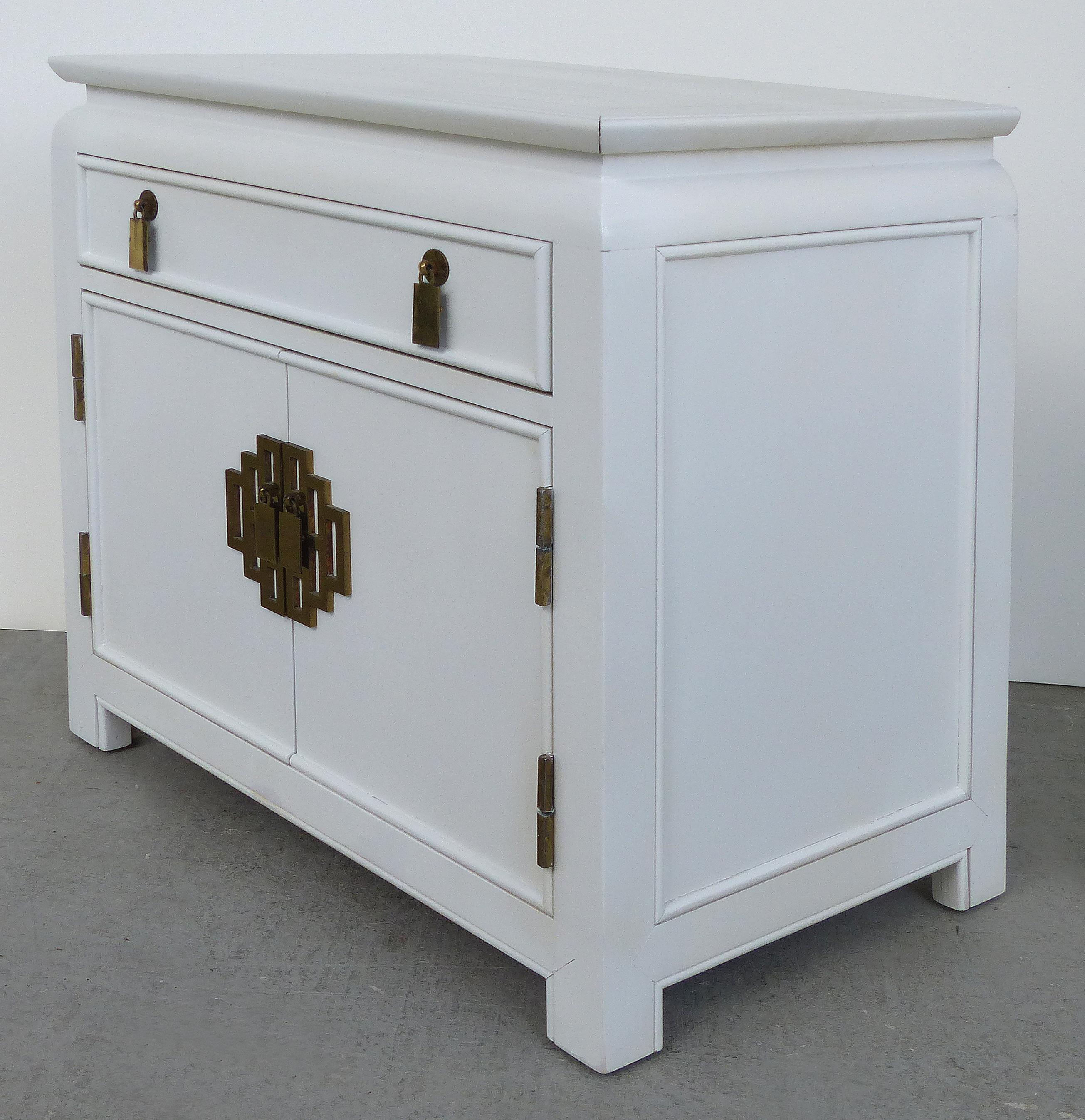 Offered for sale is a pair of midcentury Asian modern nightstands manufactured by the Century Furniture Company. These nightstands have a slender drawer above two doors that open to reveal storage space. They are lacquered in white and have