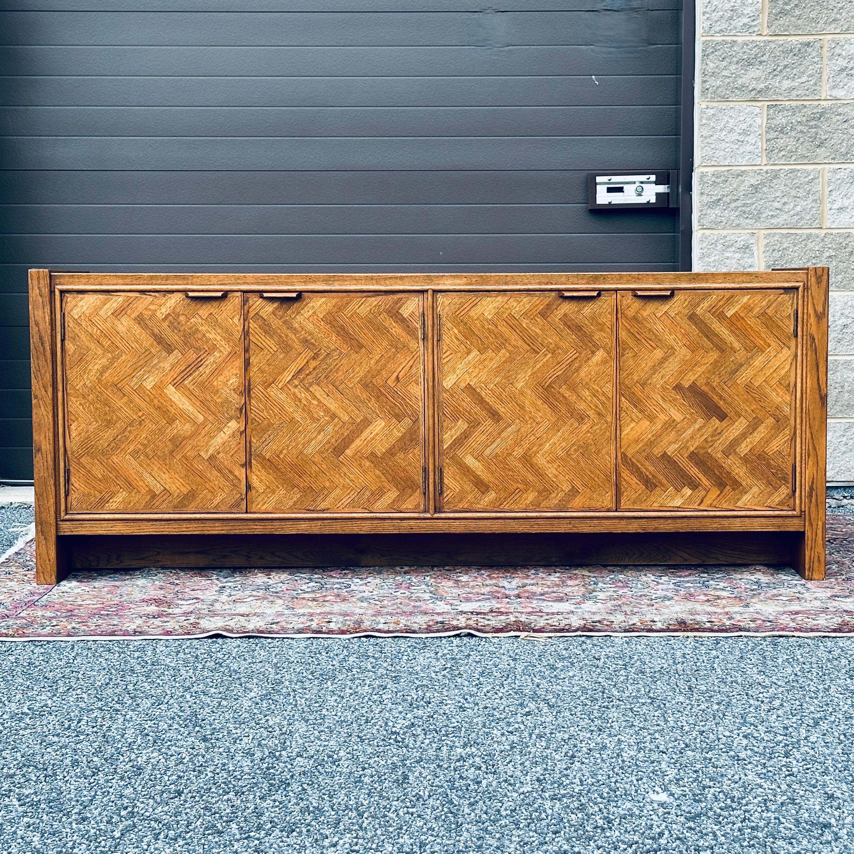 Century Furniture four door credenza with parquet door fronts. The left doors contain three pocket drawers while the right doors have cabinet space with a shelf.