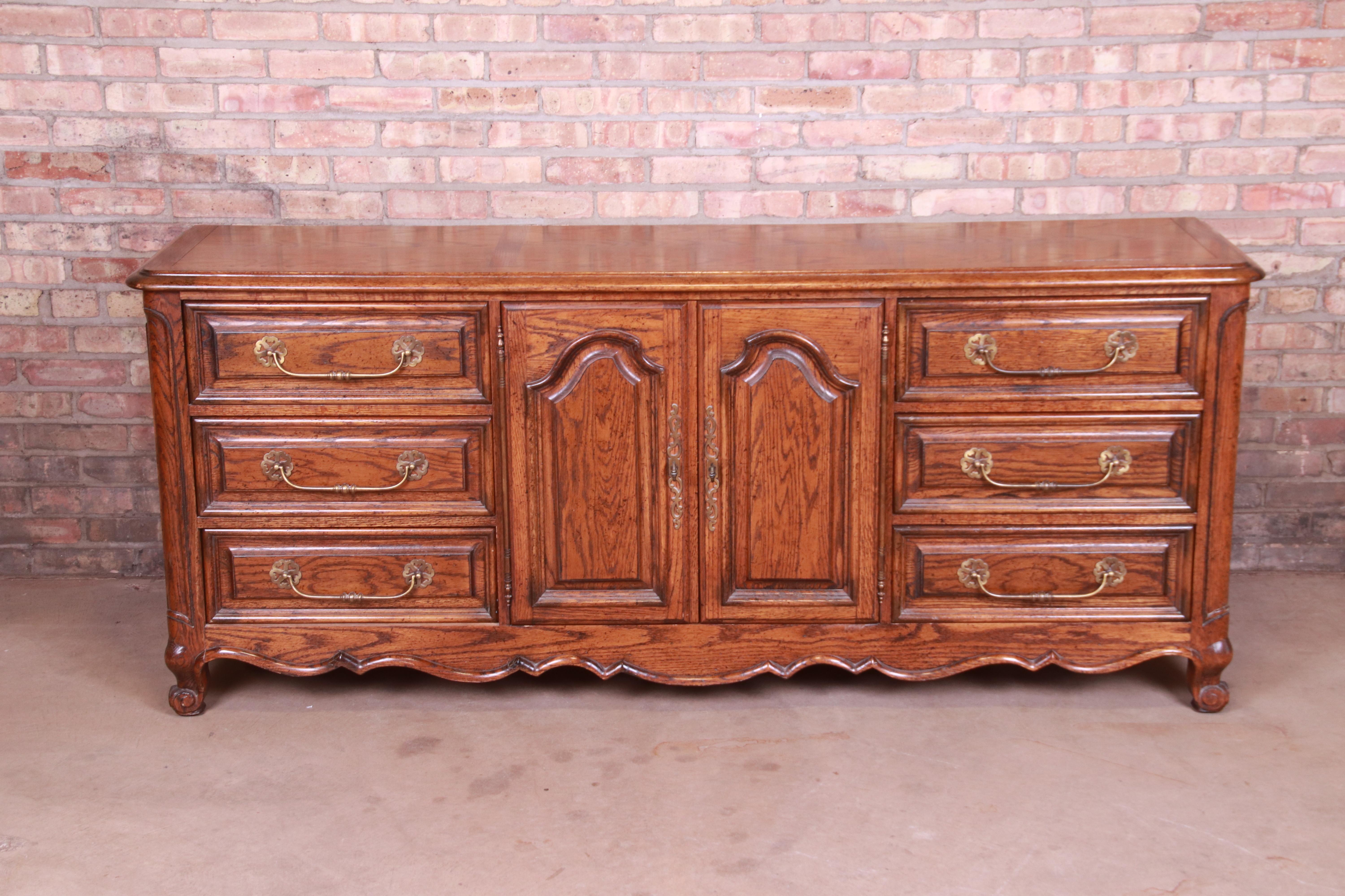 A gorgeous French Provincial Louis XV style triple dresser or credenza

By Century Furniture

USA, circa 1980s

Carved oak, with original brass hardware.

Measures: 76