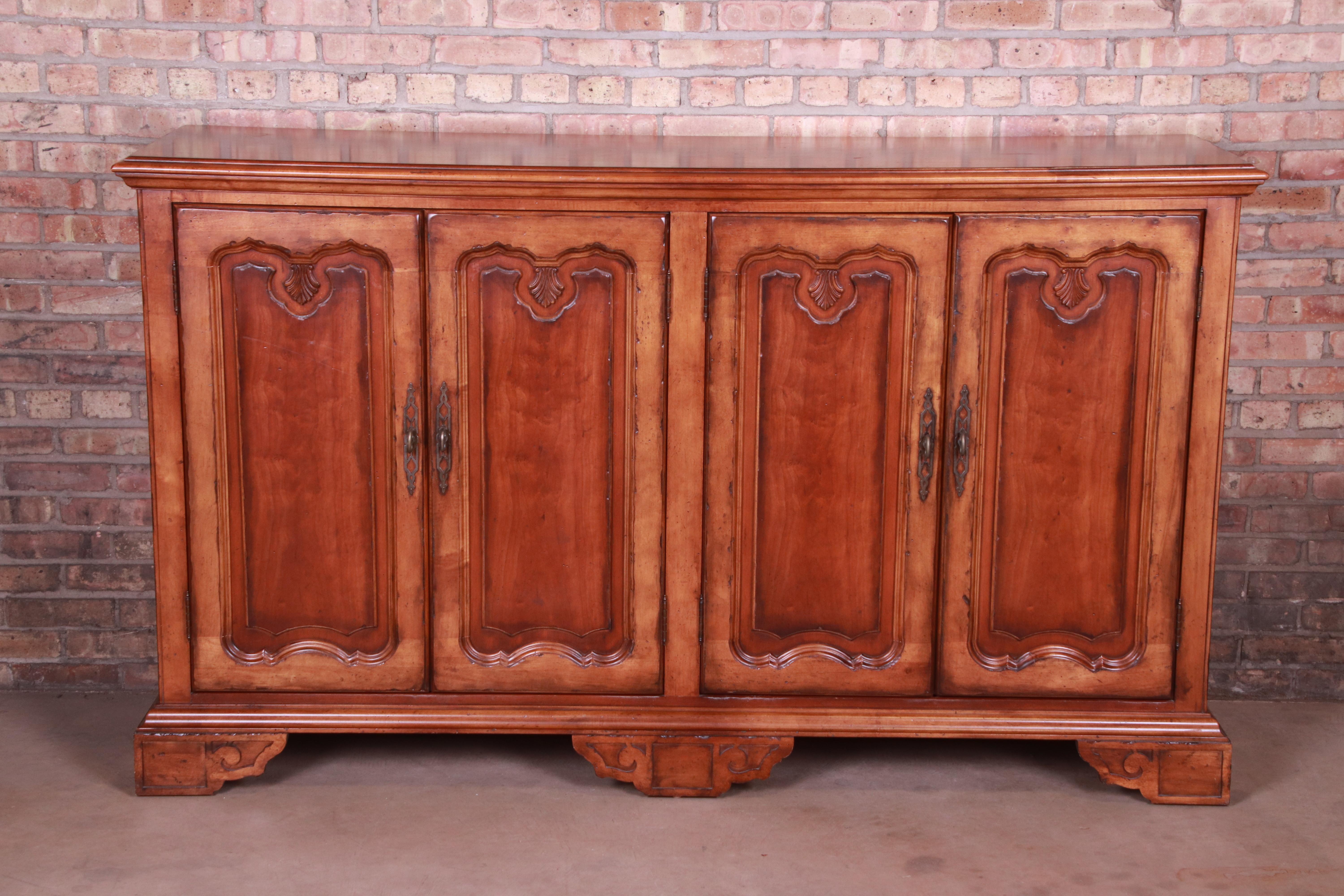 An exceptional French Provincial tall sideboard, credenza, or bar cabinet

By Century Furniture

USA, late 20th century

Carved walnut, with brass hardware.

Measures: 76.5