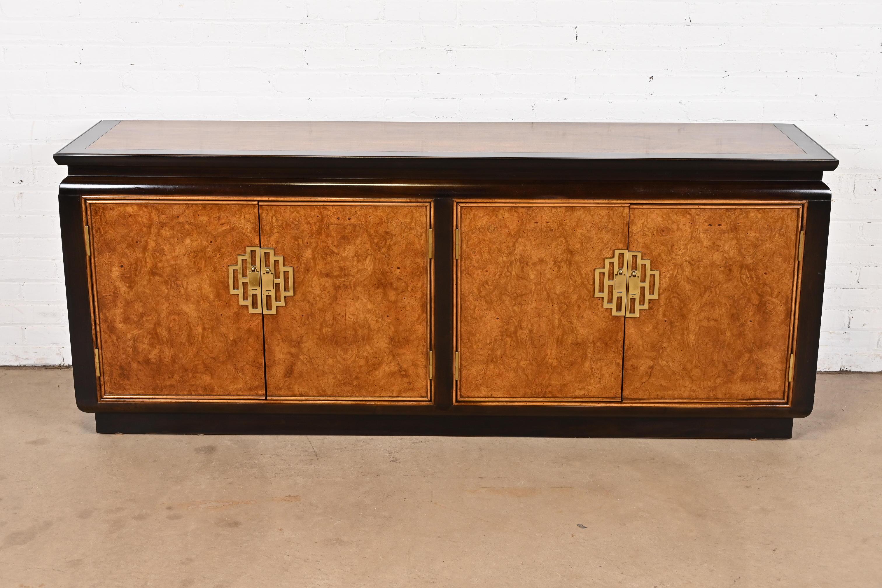 An exceptional mid-century modern Hollywood Regency Chinoiserie sideboard, credenza, or bar cabinet

By Raymond Sobota for Century Furniture

USA, Circa 1970s

Gorgeous burl wood, with ebonized trim, and original Asian-inspired brass