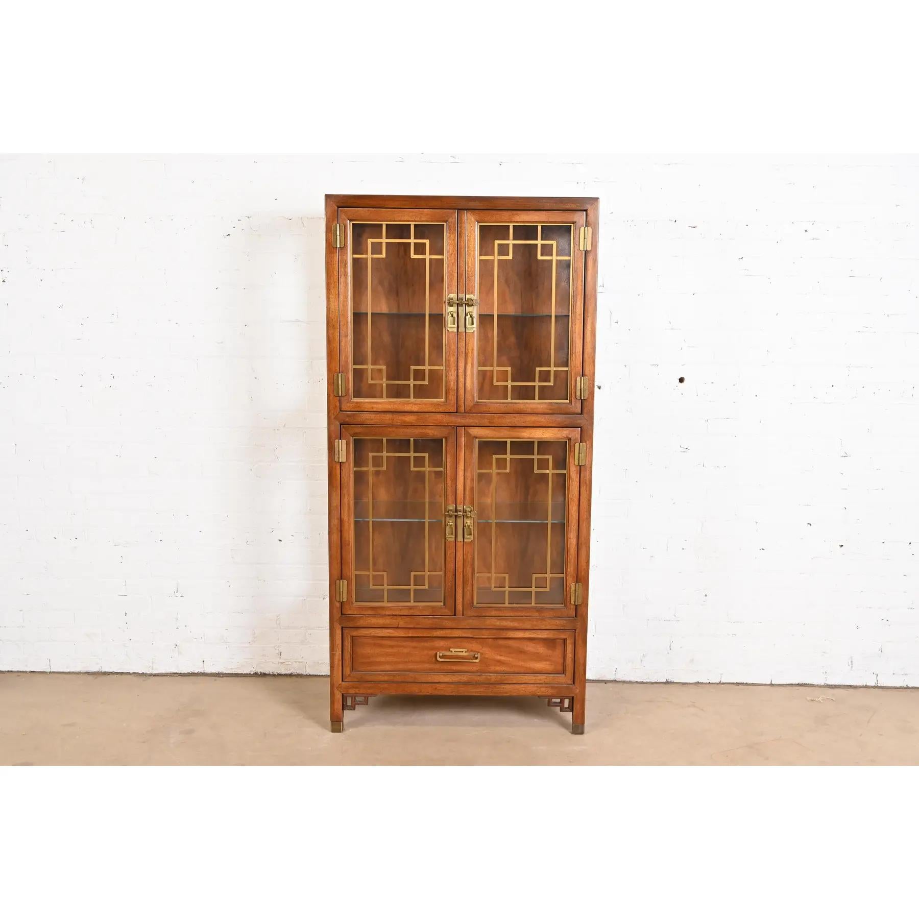An exceptional mid-century modern Hollywood Regency Chinoiserie lighted bookcase or display cabinet

By Century Furniture

USA, Circa 1970s

Walnut, with mullioned glass front and sides, and original Asian-inspired brass hardware. Shelves are