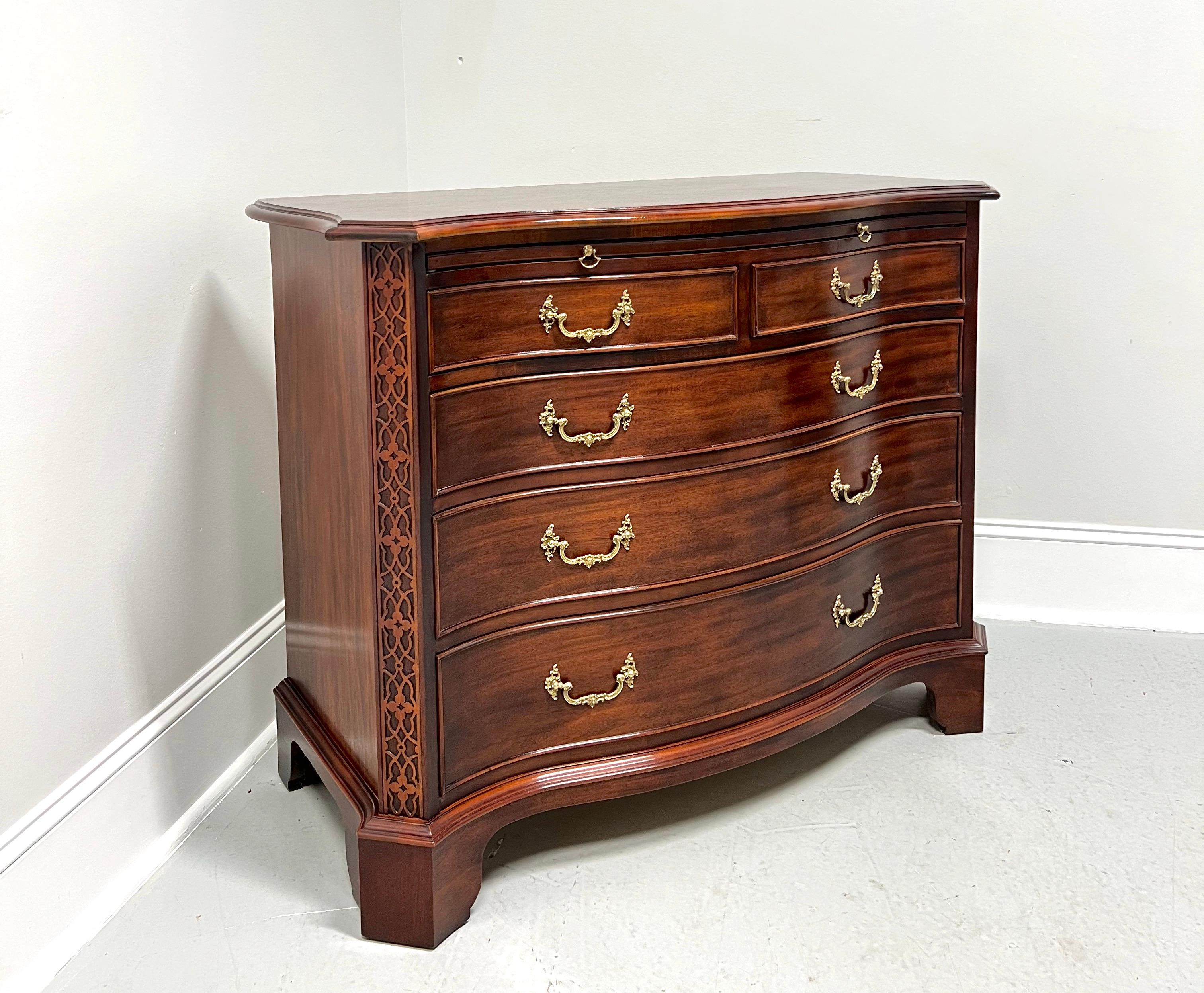 A Chippendale style bachelor chest by Century Furniture. Mahogany with brass hardware, serpentine shape, bevel edge top with clipped corners, pull-out pressing slide, decorative fretwork to front side corners, and bracket feet. Features the pressing