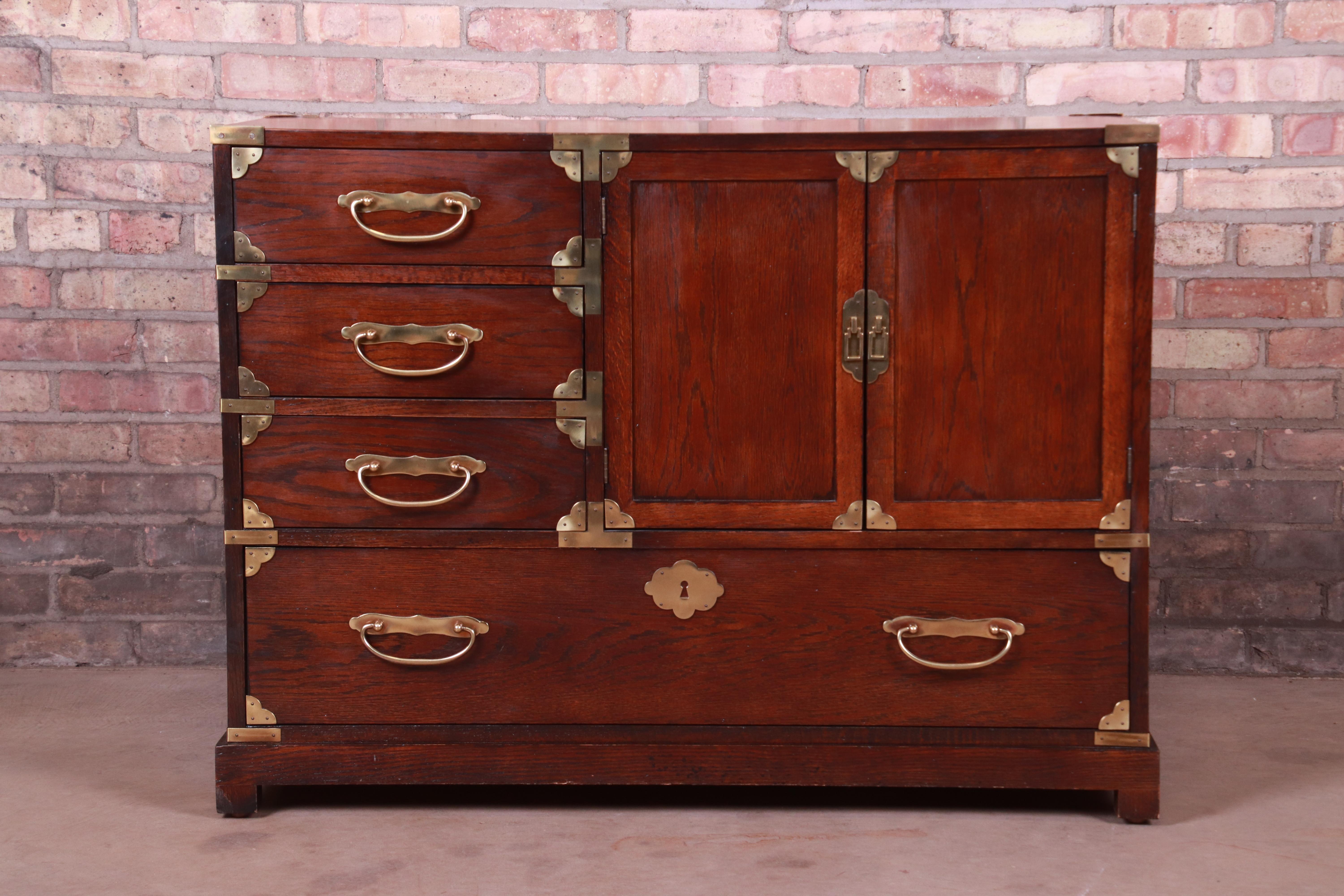 A gorgeous midcentury Hollywood Regency Campaign style dresser chest

By Century Furniture

USA, circa 1970s

Oak, with Asian-inspired brass hardware.

Measures: 41