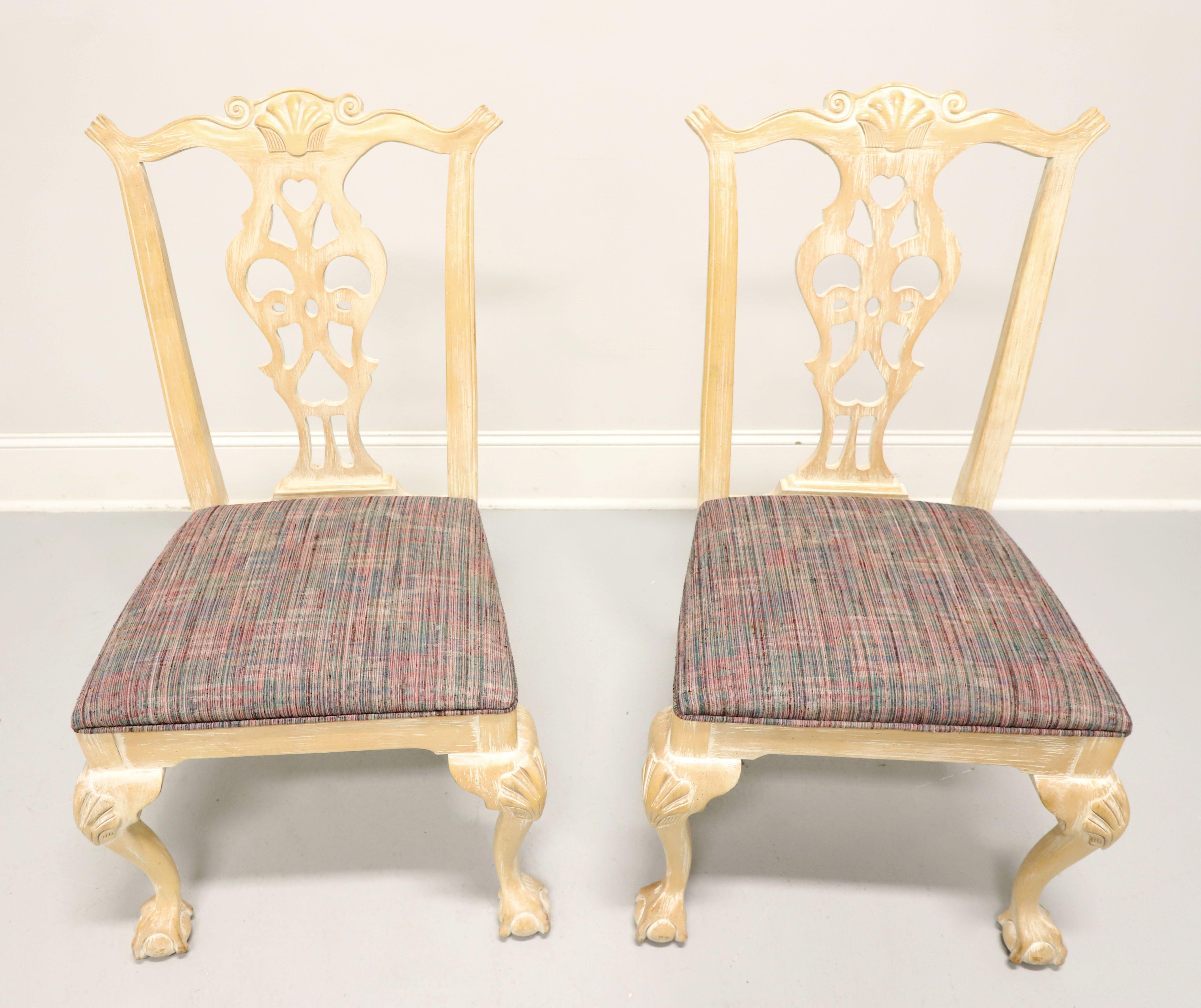 A pair of dining side chairs in the Chippendale style by Century Furniture. Solid hardwood with scrubbed white & distressed finish, carved backrest, multi-color fabric upholstered seat, carved knees, cabriole legs, and ball in claw feet. Made in