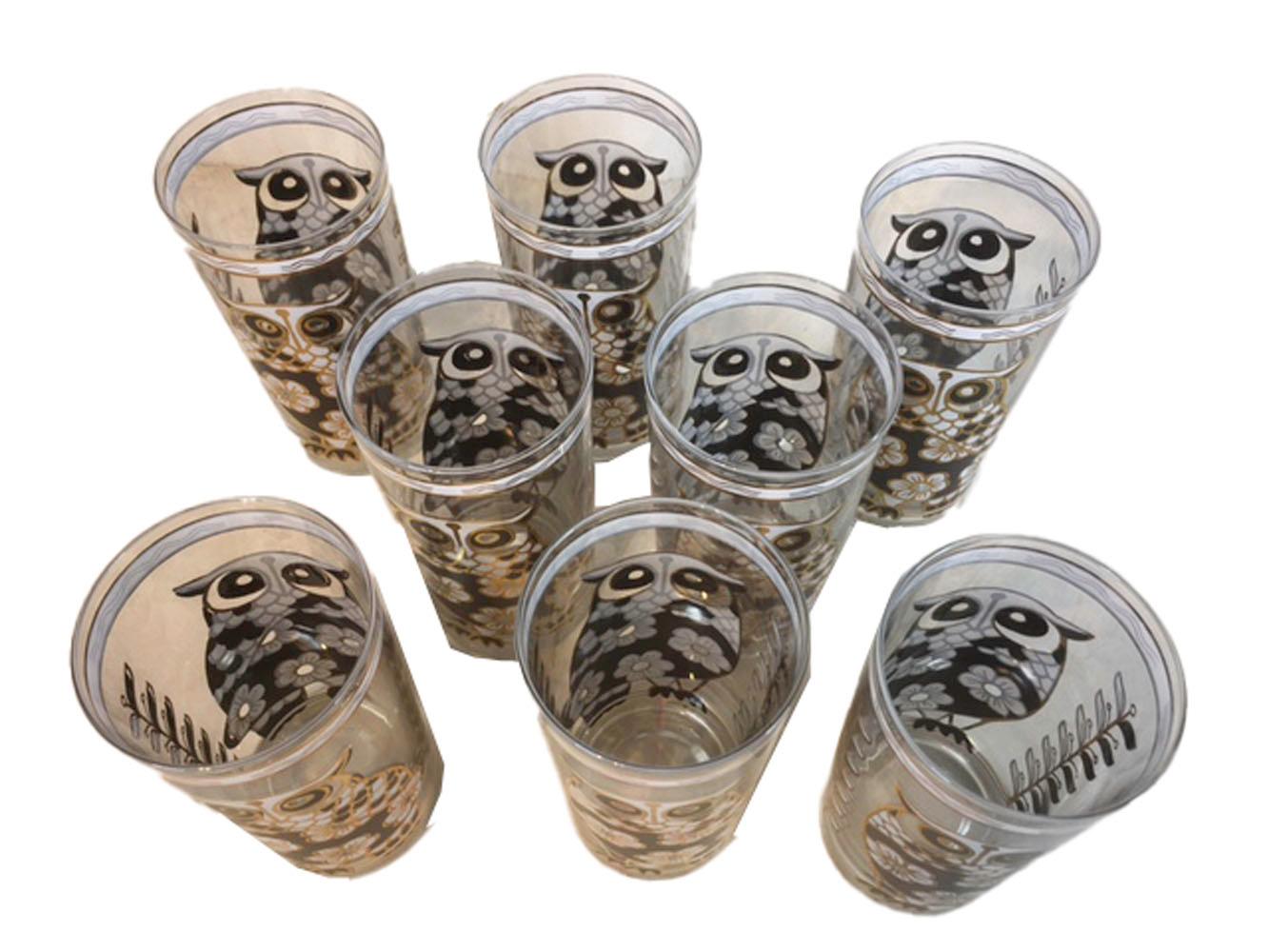 Set of eight mid-20th century highball glasses by Cera Glassware having large stylized owls and flowers in black and white enamel with gold trim. All in excellent condition.