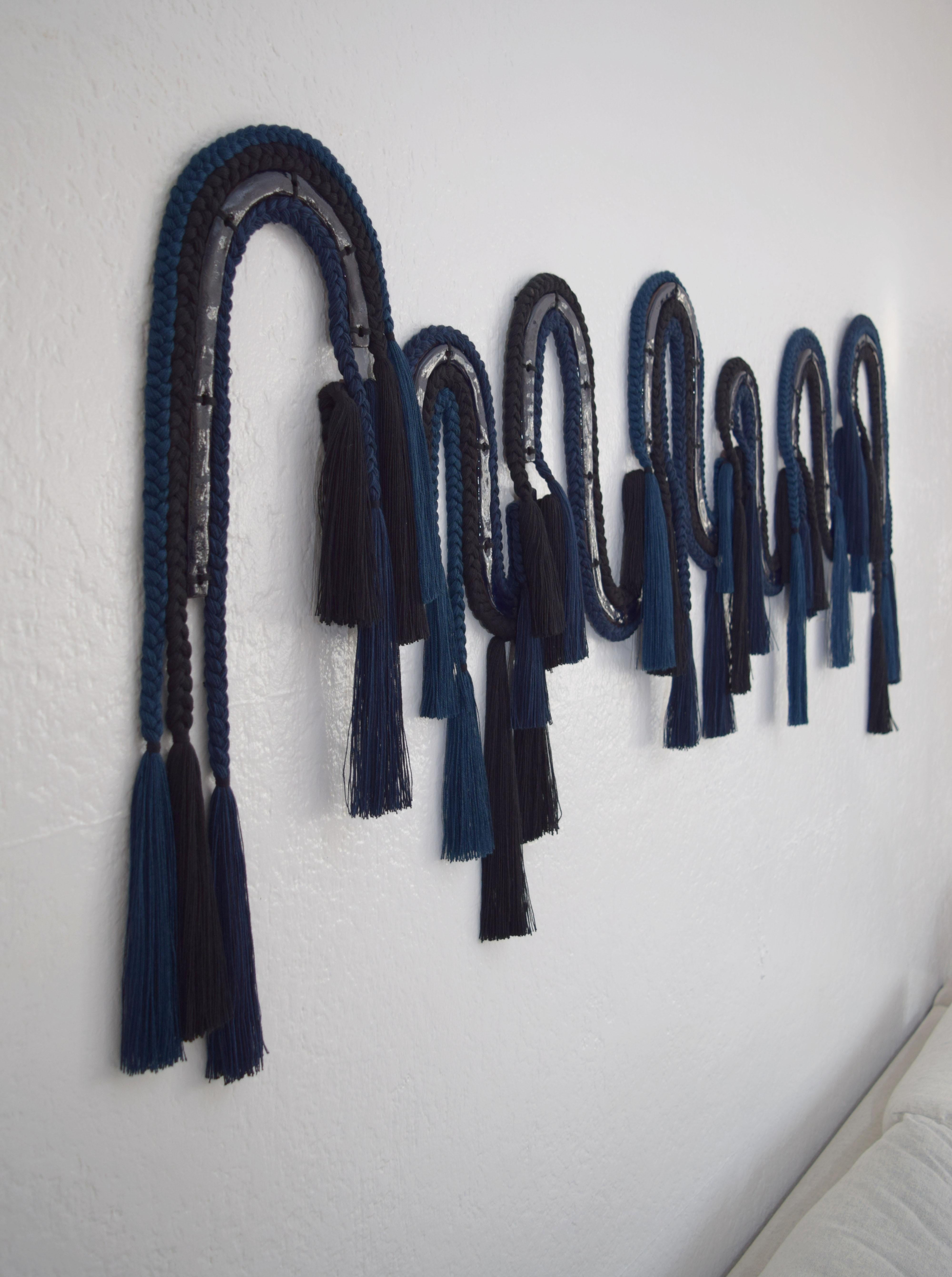 Wall sculpture #672 by Karen Gayle Tinney

7-panel wall sculpture in mixed materials of ceramic and braided cotton/tencel fibers. A ceramic core, glazed in deep navy blue is surrounded by braids in different textures and weights; navy cotton, navy
