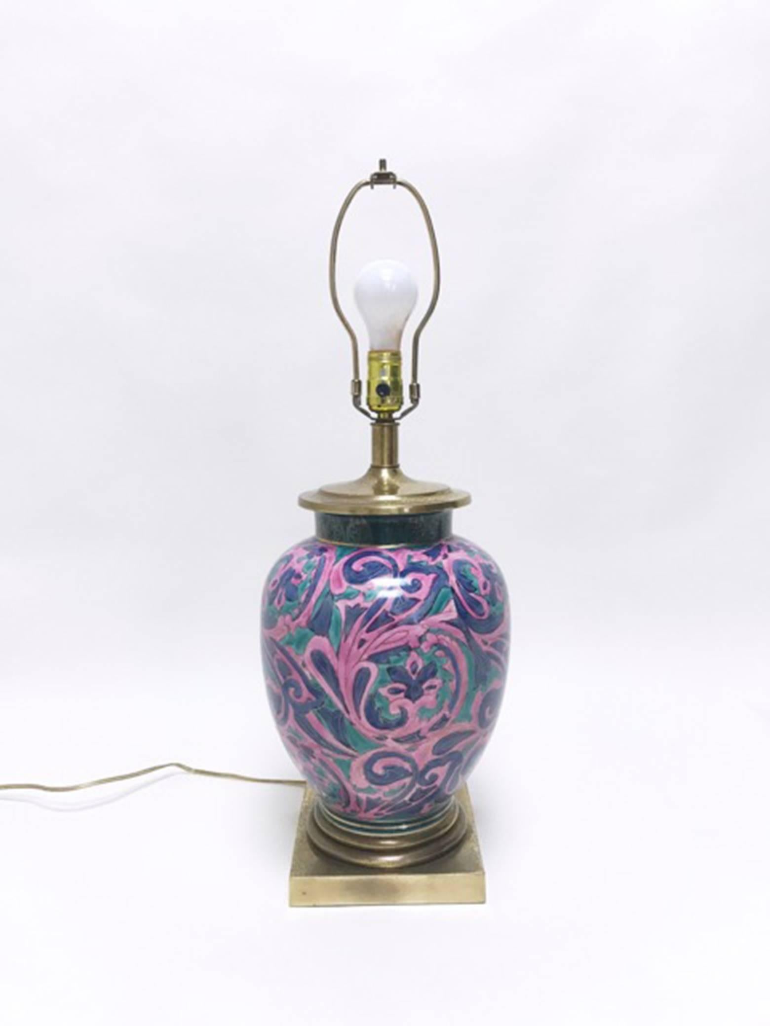 Hand-painted and glazed ceramic ginger jar form table lamp with brass base and neck. Floral motif in shades of pink, blue and green with gold detailing. Produced by Frederick Cooper, Chicago. Lamp retains Frederick Cooper label. 

Shade included.