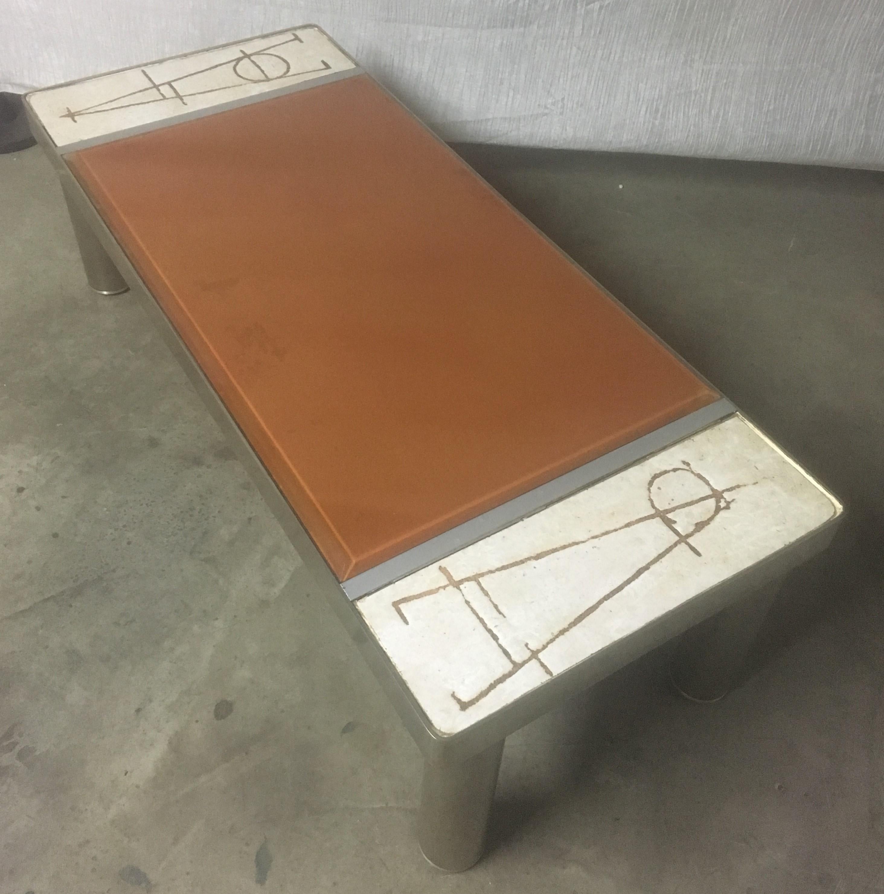 A ceramic and chromed metal rectangular table made in Vallauris in South of France, circa 1970.
The tray is composed of 2 ceramic plates with abstract decoration and a brown glass slab in the center. It rests on 4 cylindrical feet in chromed