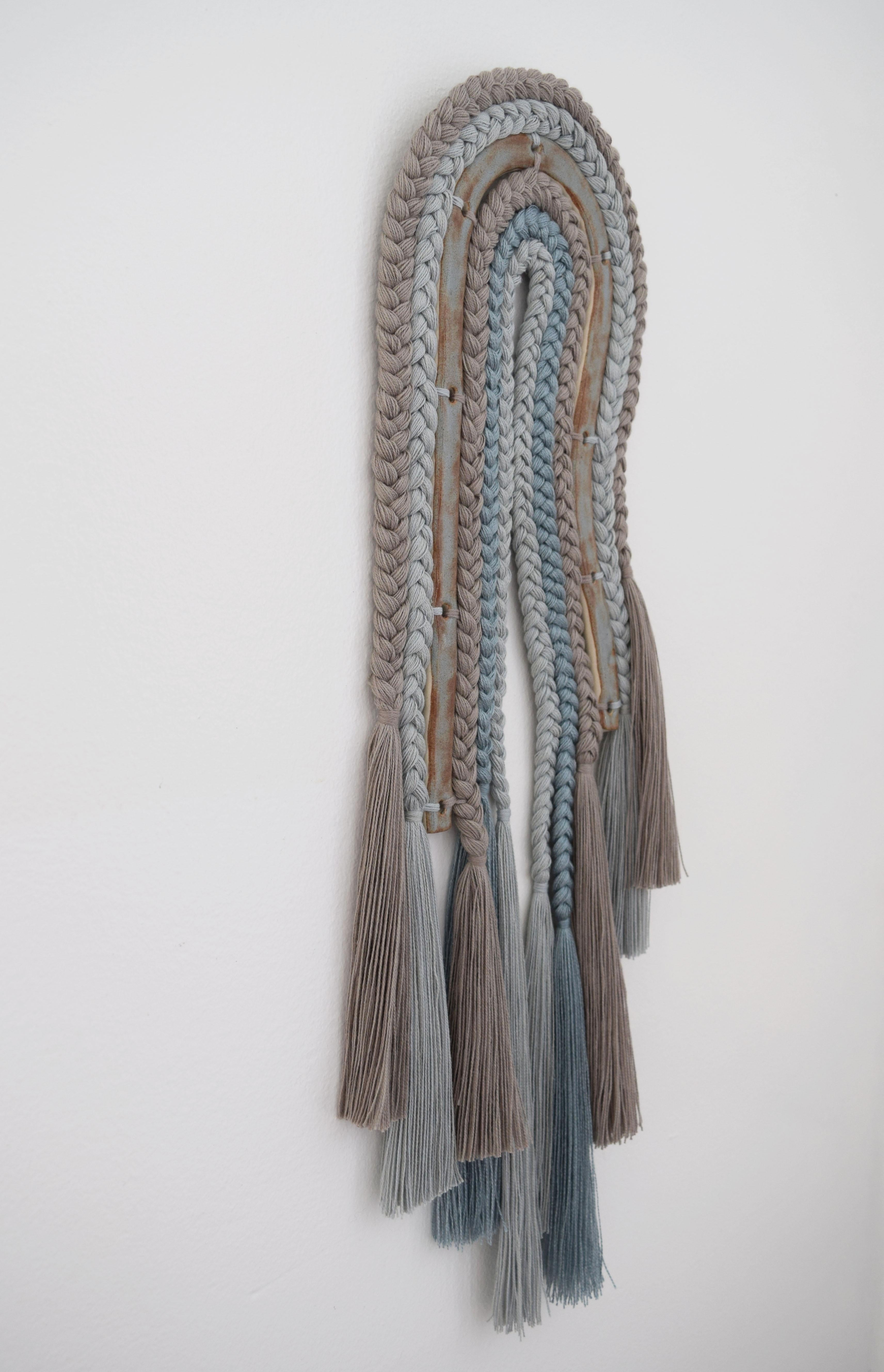 Wall sculpture #680 by Karen Gayle Tinney

Mixed material wall sculpture comprised of a ceramic panel with applied cotton and tencel braids, transitioning into fringe. The ceramic piece is hand formed out of stoneware and glazed in blue/rust