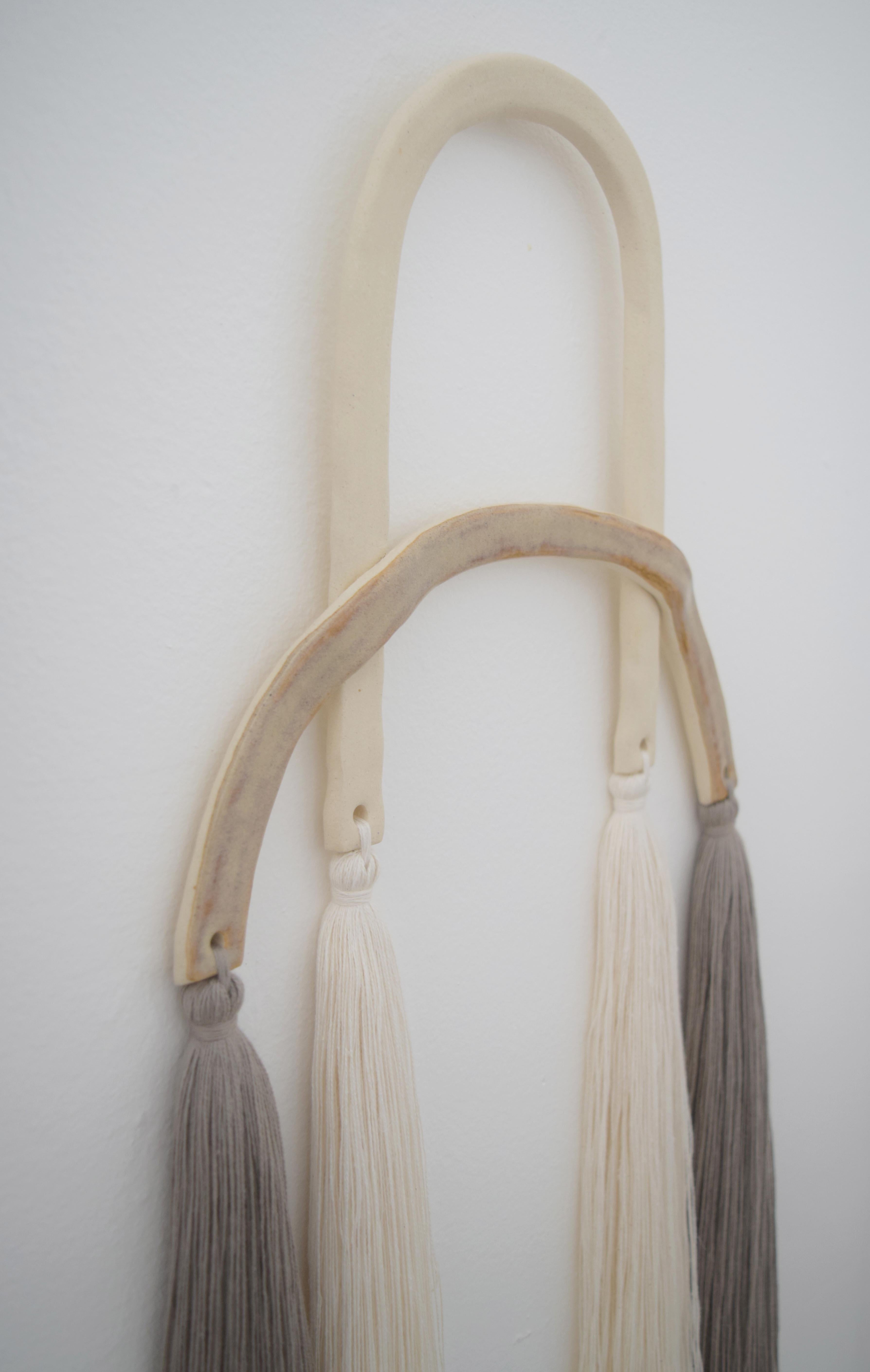 Wall sculpture #530 by Karen Gayle Tinney

Wall sculpture in mixed materials of ceramic and cotton fibers. A ceramic frame, partially unglazed stoneware, and partially glazed in speckled gray is finished off in lengthy cotton fringe. The sculpture