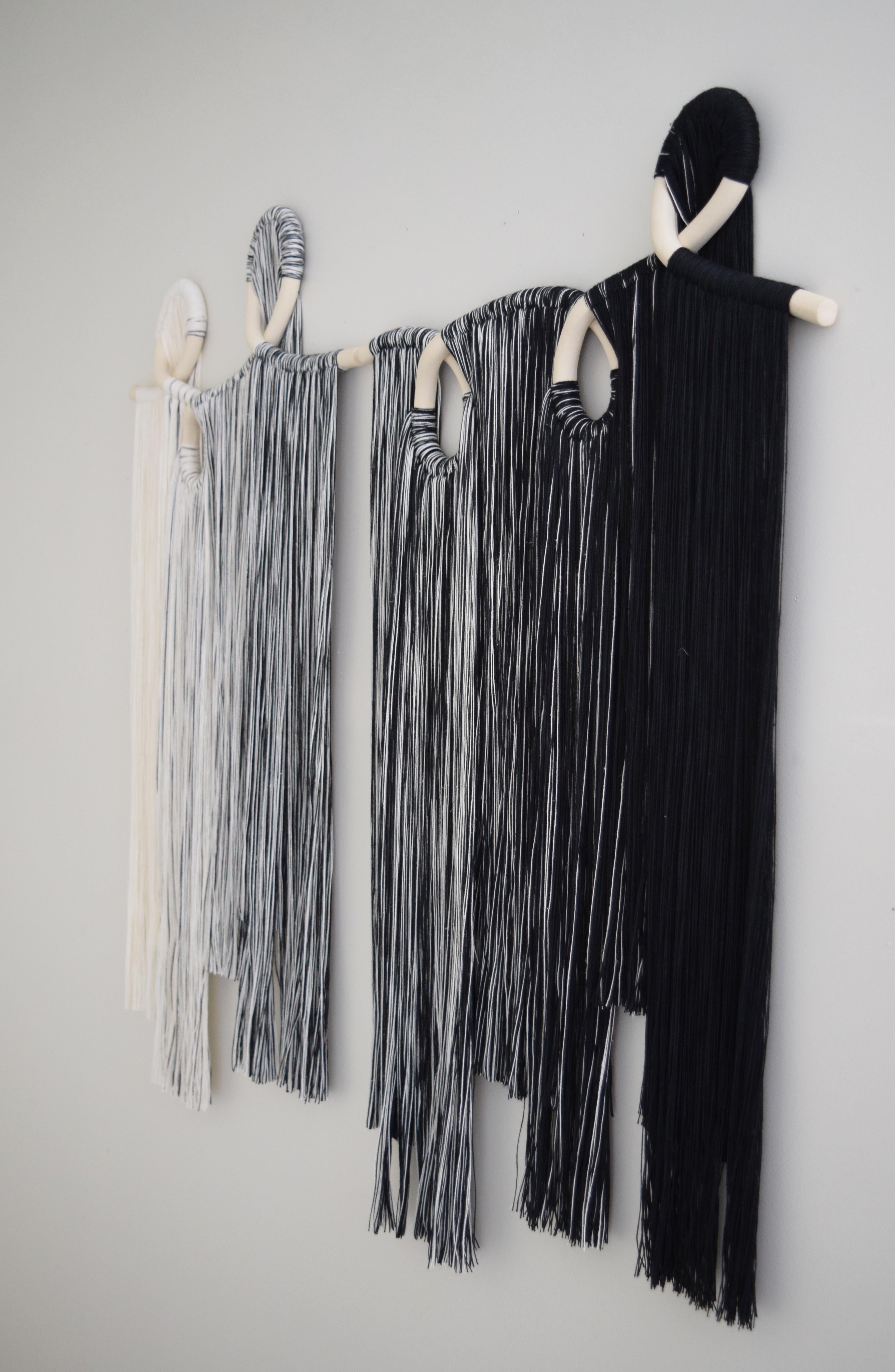 Sculpture murale à deux panneaux. Pièces en céramique formées à la main en grès blanc non émaillé avec frange en coton noir et blanc. Un fil de suspension est inclus dans chaque panneau. Livré avec un petit peigne pour les franges et les