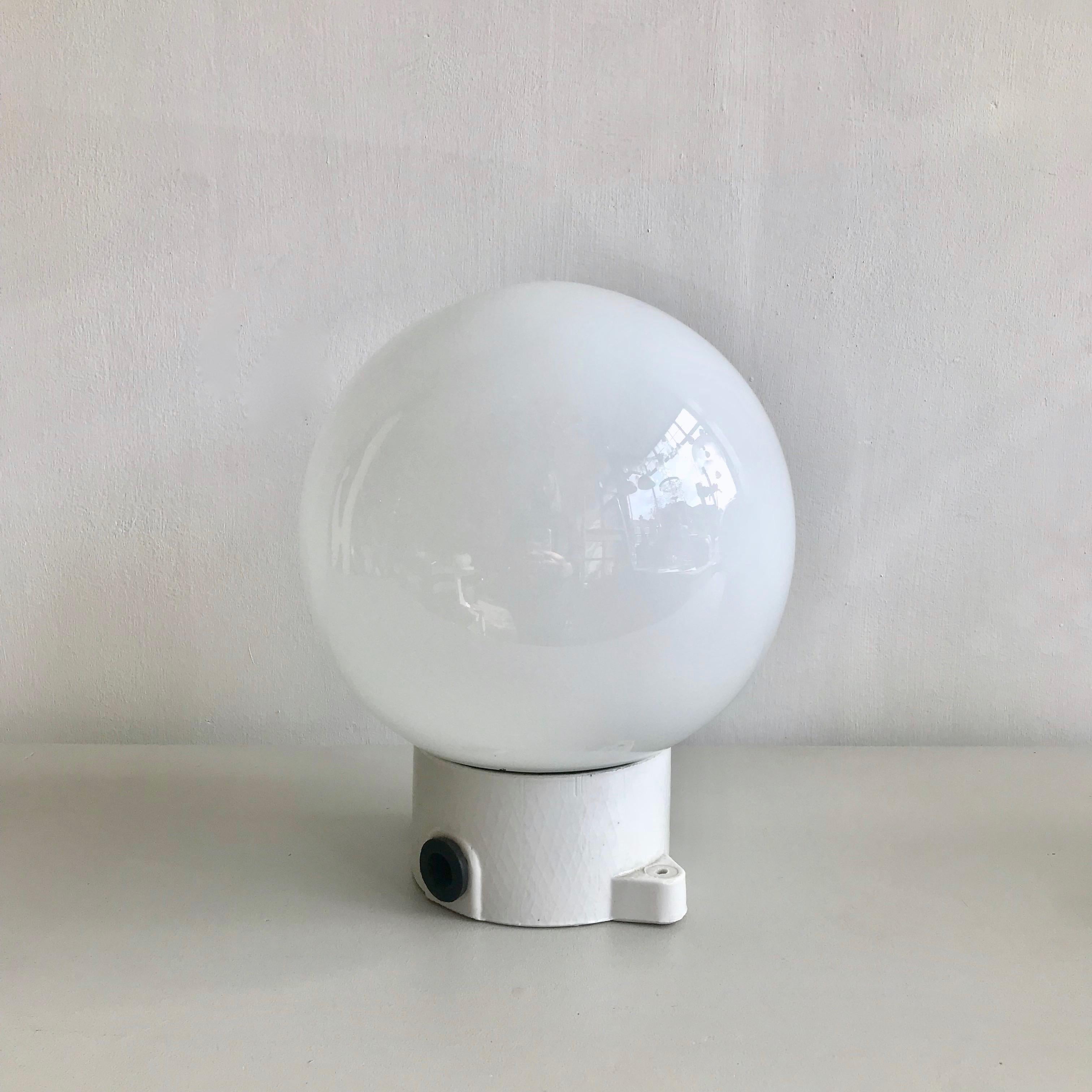 Five ceramic and opaline lights. Suitable for wall lights or ceiling mounted. Original industrial lights in excellent condition. The pendants are rewired and in working order. The glass shade screws into the ceramic fitting.