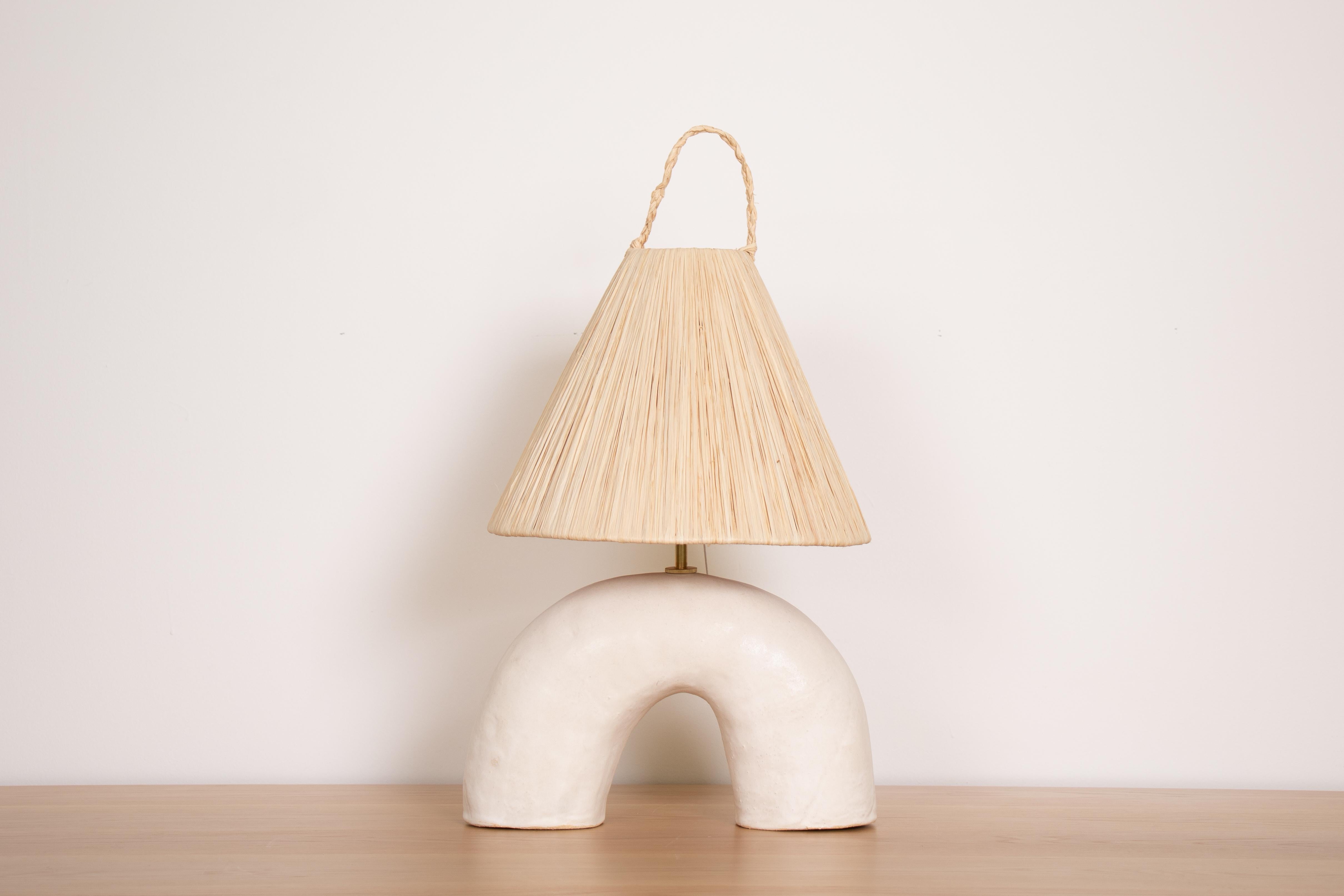 New ceramic lamp in arch form handmade from terracotta and white glaze. New wiring, brass stem neck, and natural raffia shade. Modern organic form with a nice mix of materials. Made in Spain. 

Bulb info: LED max 60 watt with medium base bulb