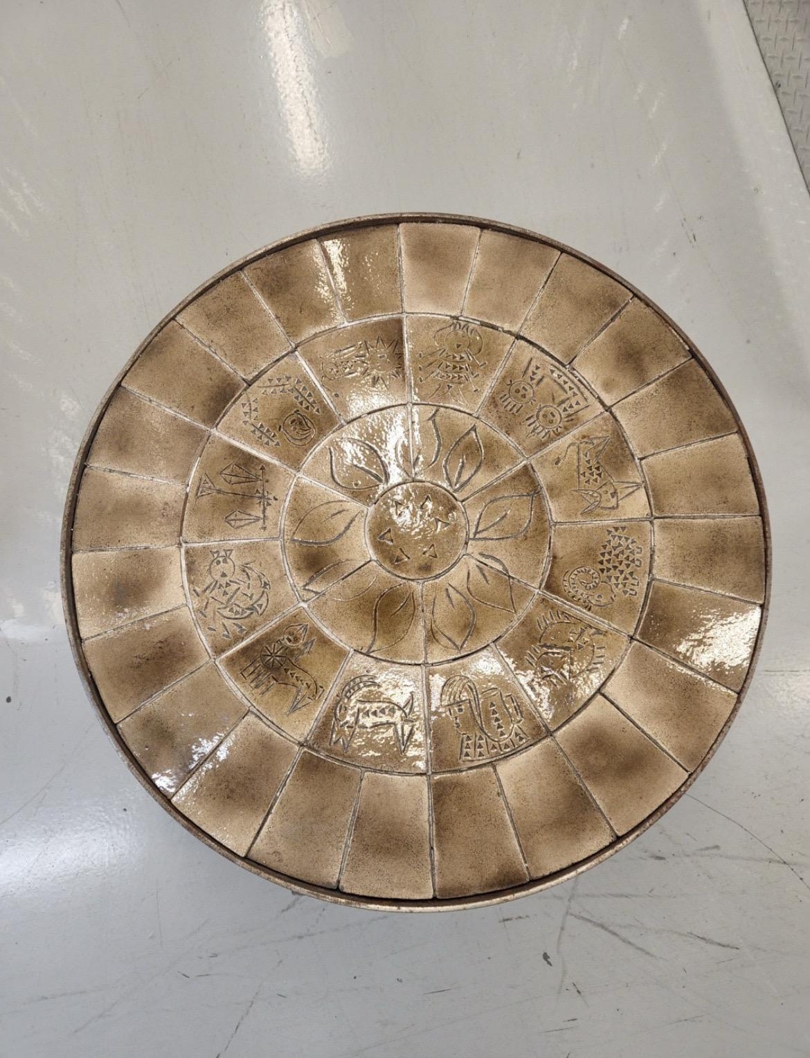 Incroyable et originale table basse française en acier et céramique. Le haut est d'une belle couleur neutre. Vous pouvez voir 12 signes astrologiques imprimés dans les carreaux. Pour les amateurs de vintage et d'ésotérisme. 