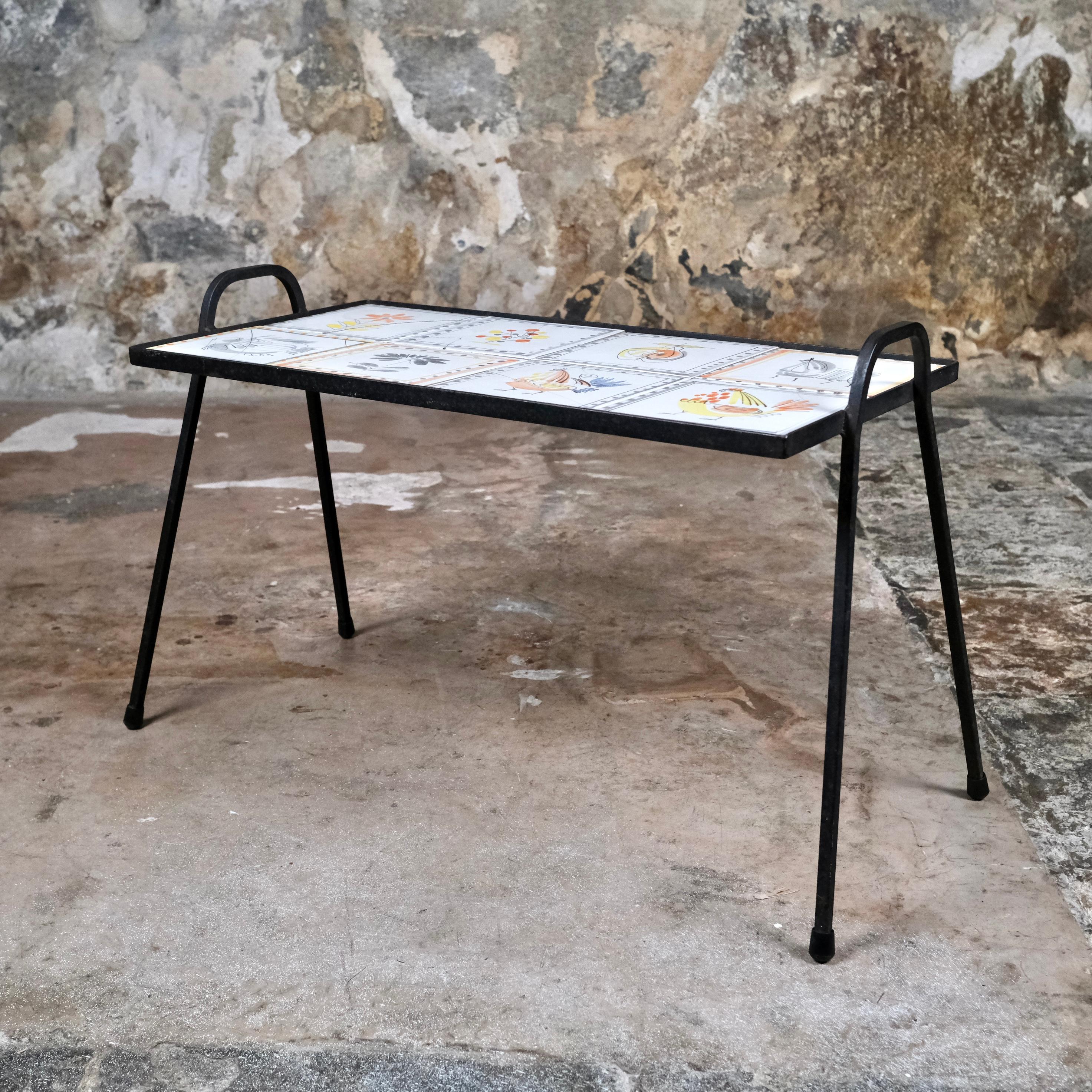 Schöner Beistelltisch aus Keramik und Schmiedeeisen, hergestellt von Roger Capron in seiner Werkstatt in Vallauris, Ende der 1950er, Anfang der 1960er Jahre.
8 emaillierte Steingutfliesen, mit polychromen Blumen- und Tierdekorationen und Fries.
6