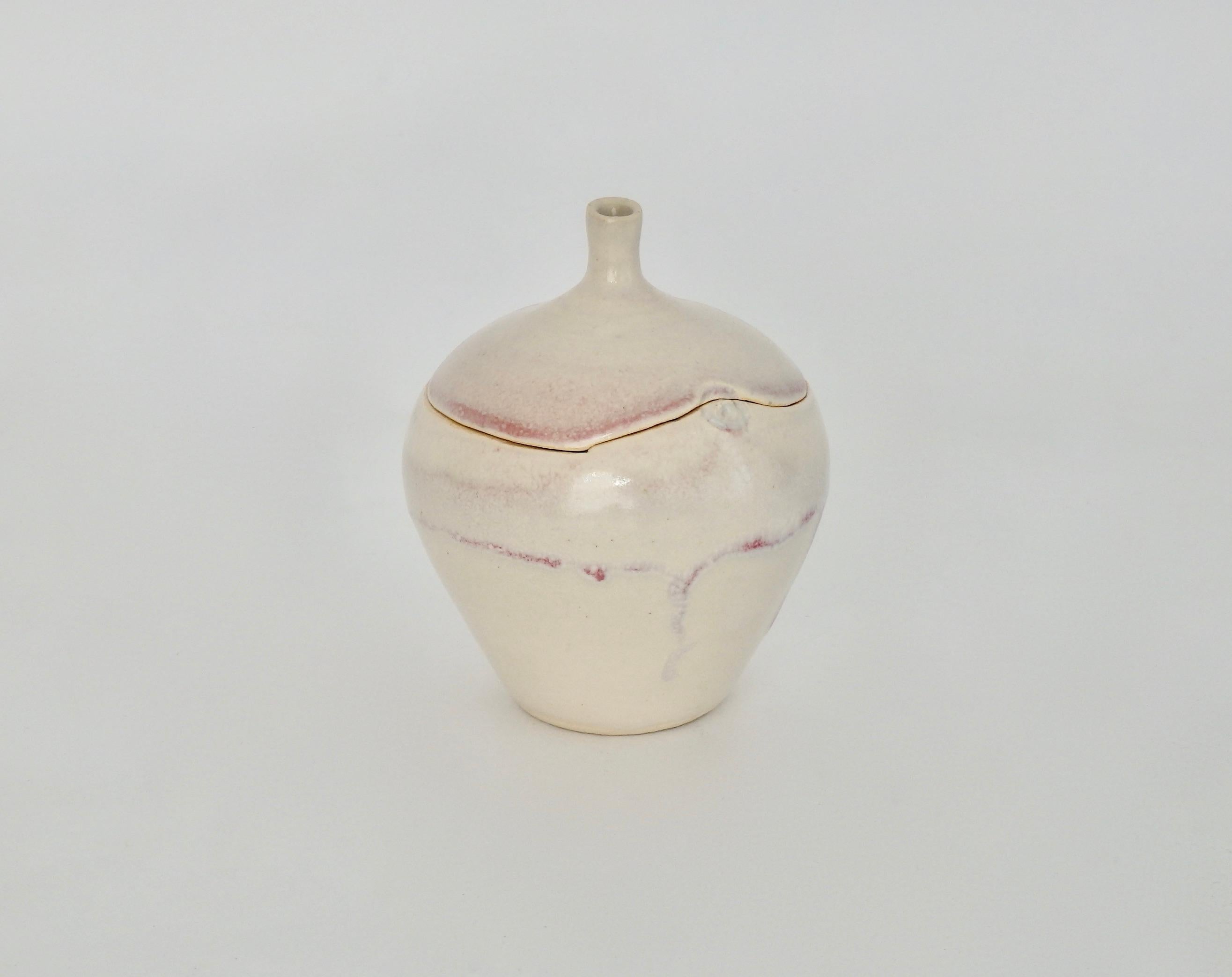 Charming ceramic apple sculpture with a rich cream and red high glaze.