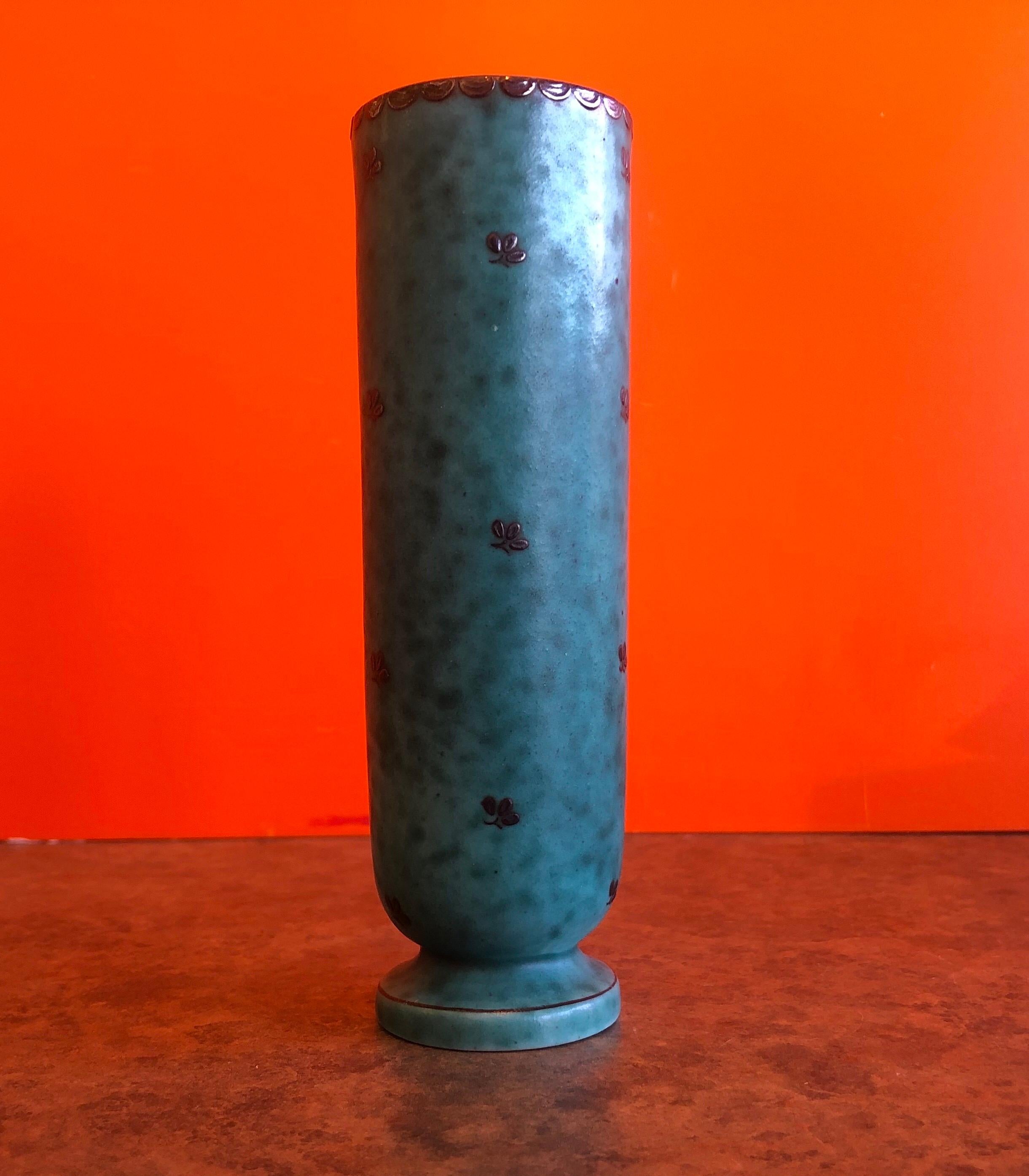 Beautiful ceramic Art Deco bud vase by Wilhelm Kage for Argenta, circa 1940s.

The vase has a green ceramic finish with a silver flower motif overlaid.

This vase is in excellent used condition with no chips or cracks and measures 1.75