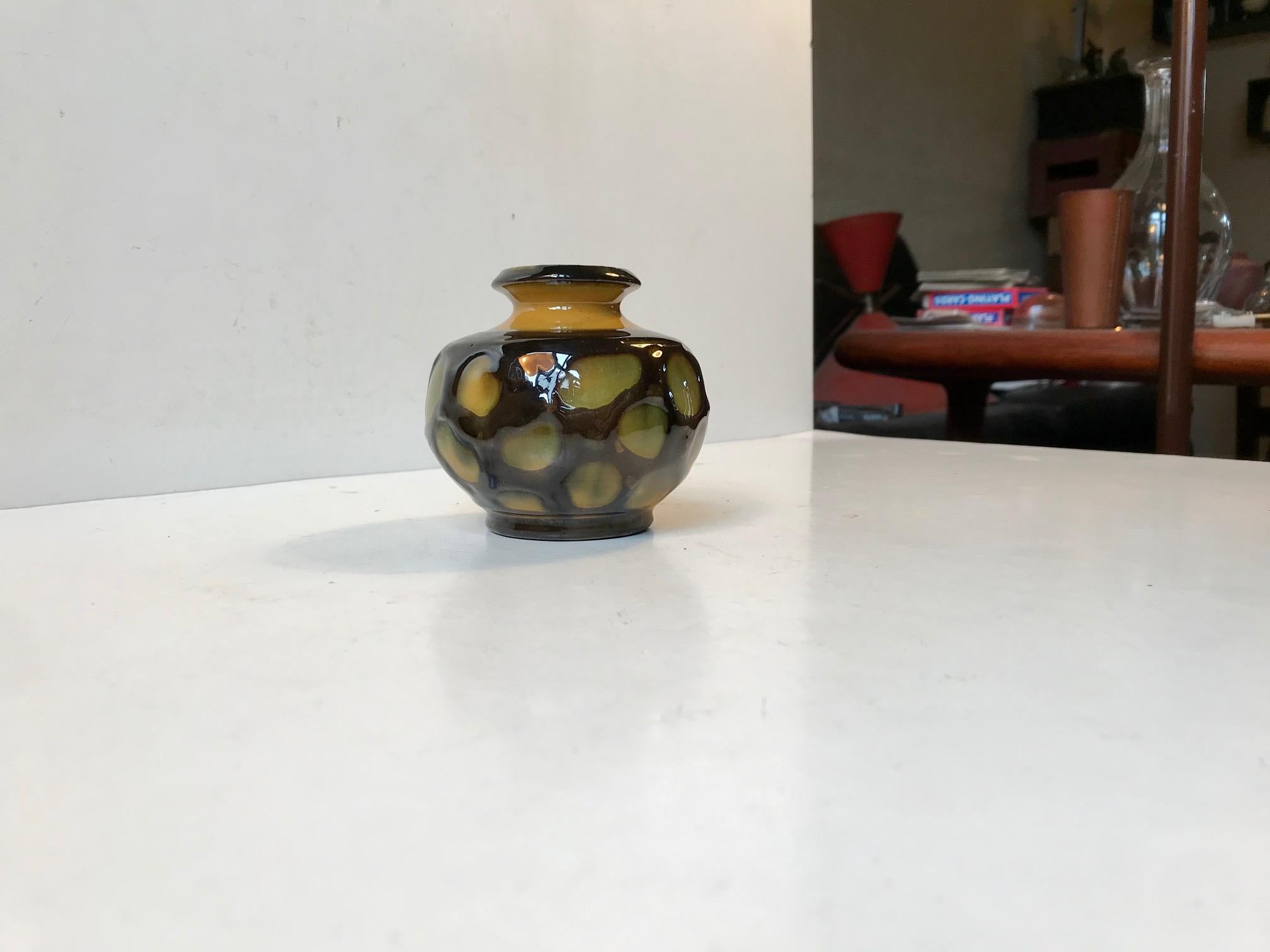 Small grenade shaped vase decorated with dots in high-gloss green, yellow and black glazes. Made by Herman August Kähler and is signed HAK - Denmark to the base.