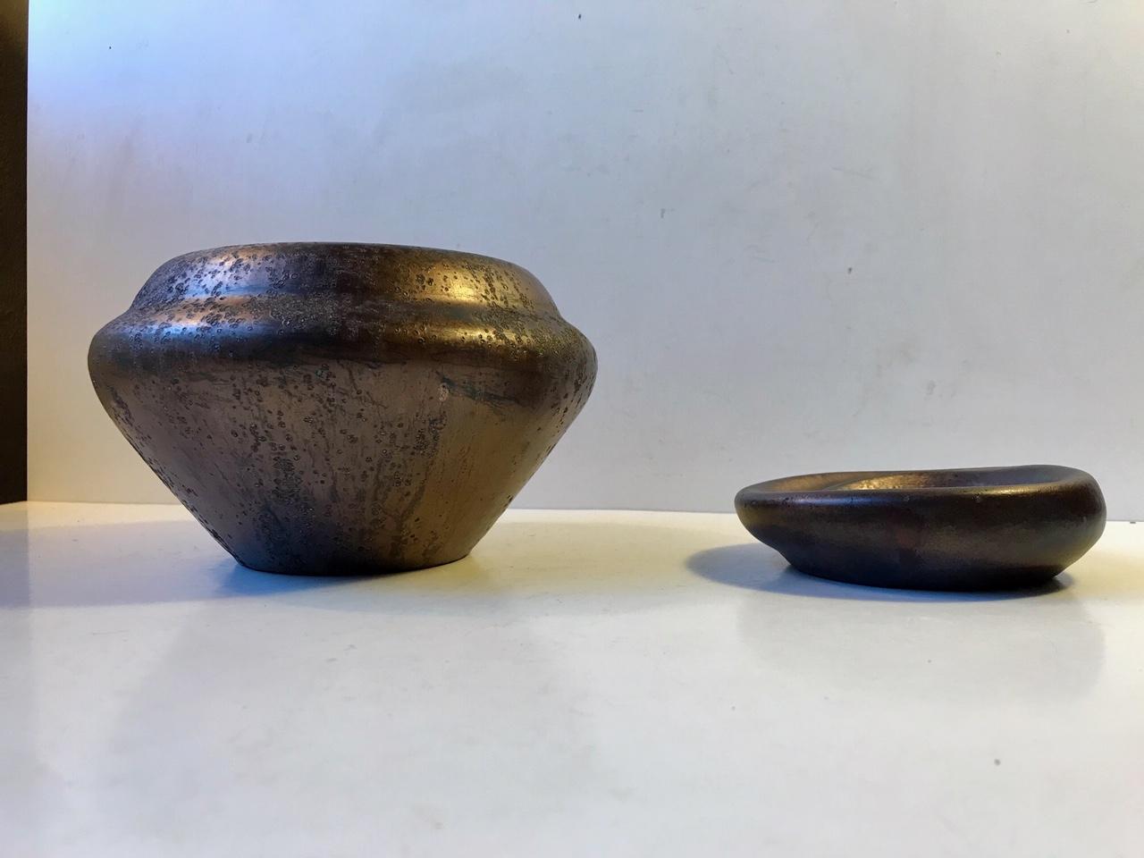 Vase and small matching dish from the workshop of Soren Kongstrand. These pieces are designed by his colleague and apprentice Jens Petersen. Both are unique pieces from circa 1935 and signed JP. Experimental glazes: metallic/copper based luster