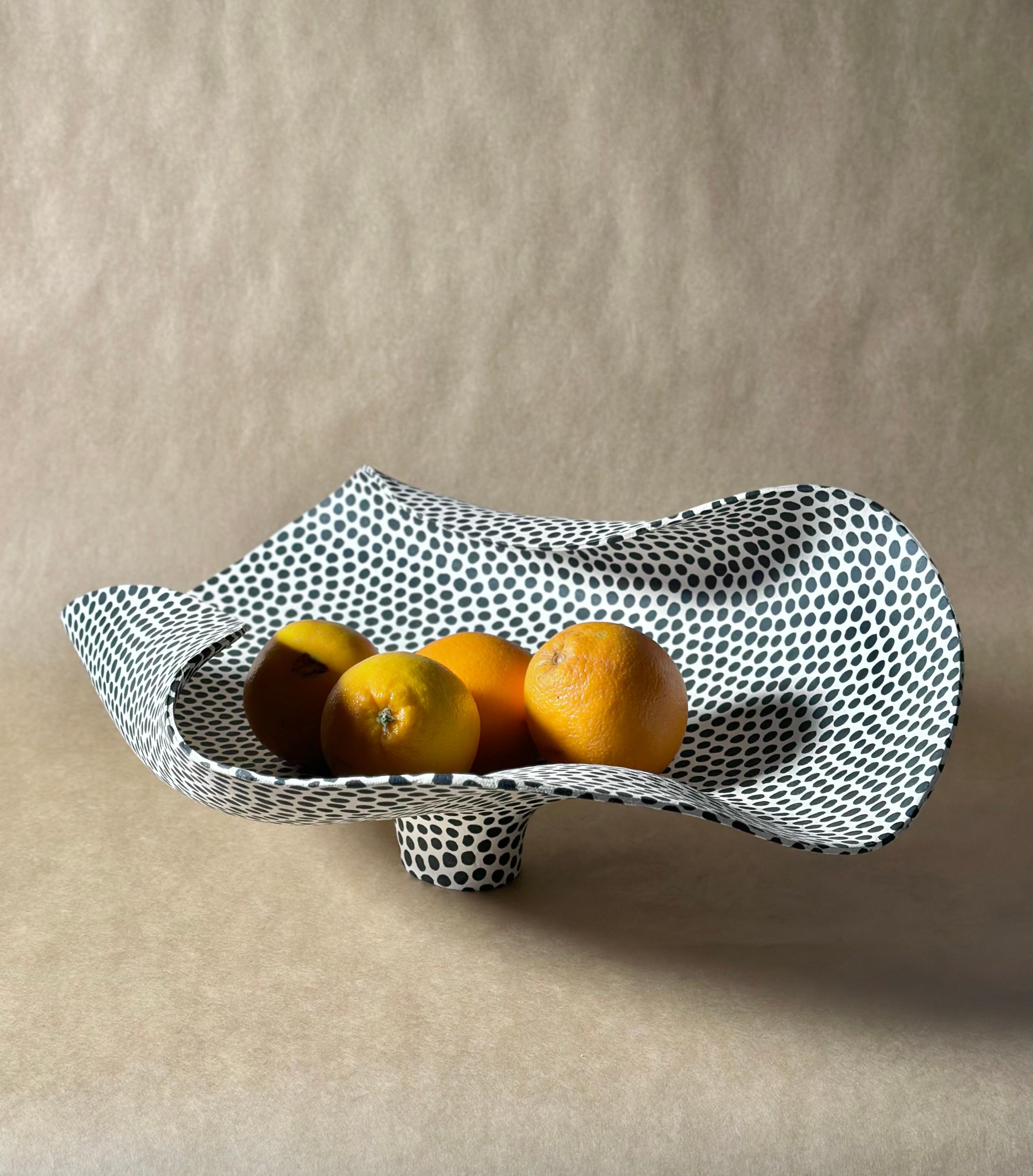 Art piece by  Norwegian ceramic artist Johanne Birkeland. Birkeland works under the artist name Jossolini. 

All her pieces are unique, and are built or thrown by hand. The decoration is also made by hand, using a black, matte glaze. She works