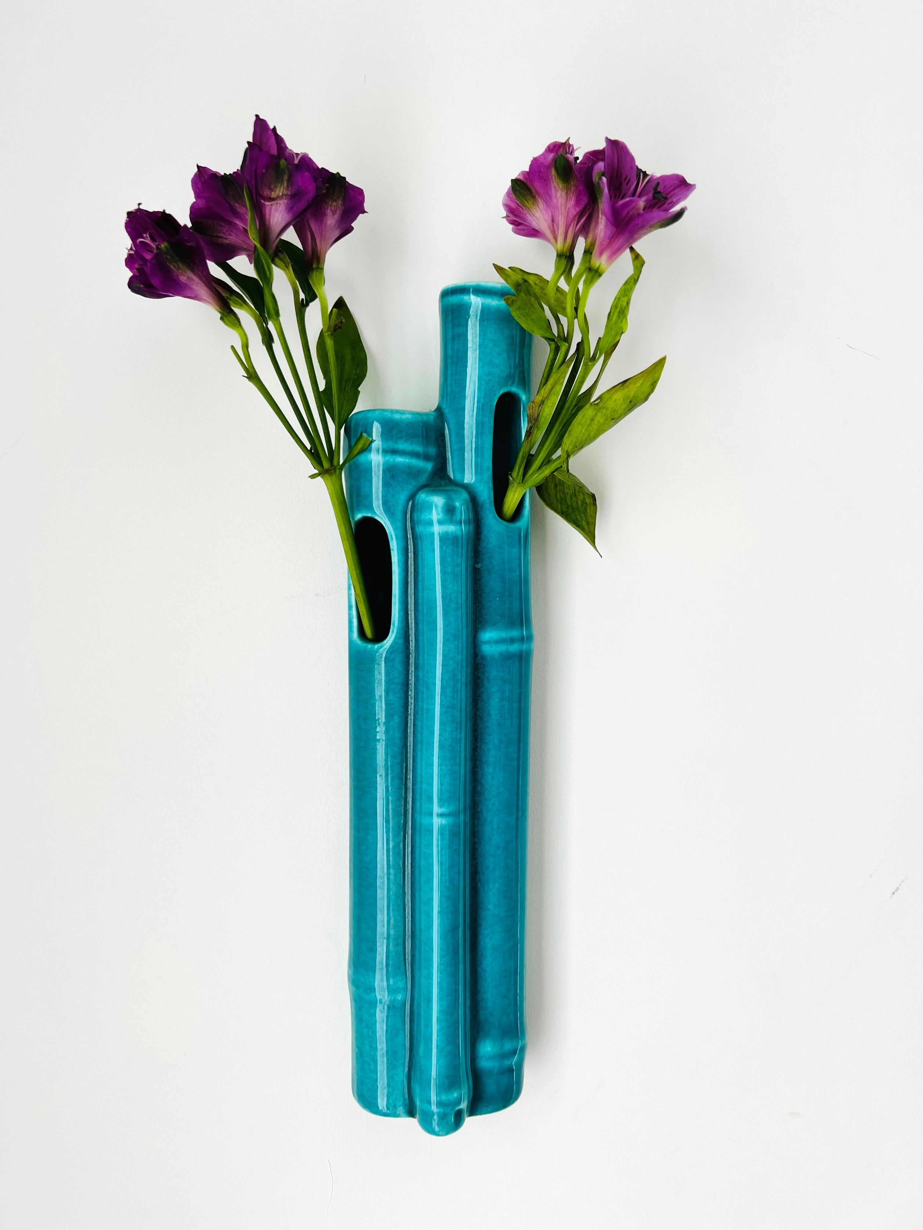 Mid-Century Modern wall pocket vase with bamboo cluster design. Handmade ceramic pottery features a turquoise glaze finish. The vase has one opening along the top and two along the front of the vase.