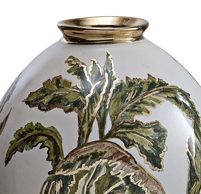 A captivating work of art, this stunning ceramic vase will enliven any decor. An array of overlapping banana leaves lined in exquisite gold-coin adorn the surface, the deep green hues of leaves elegantly contrasting with the metallic accents. Its